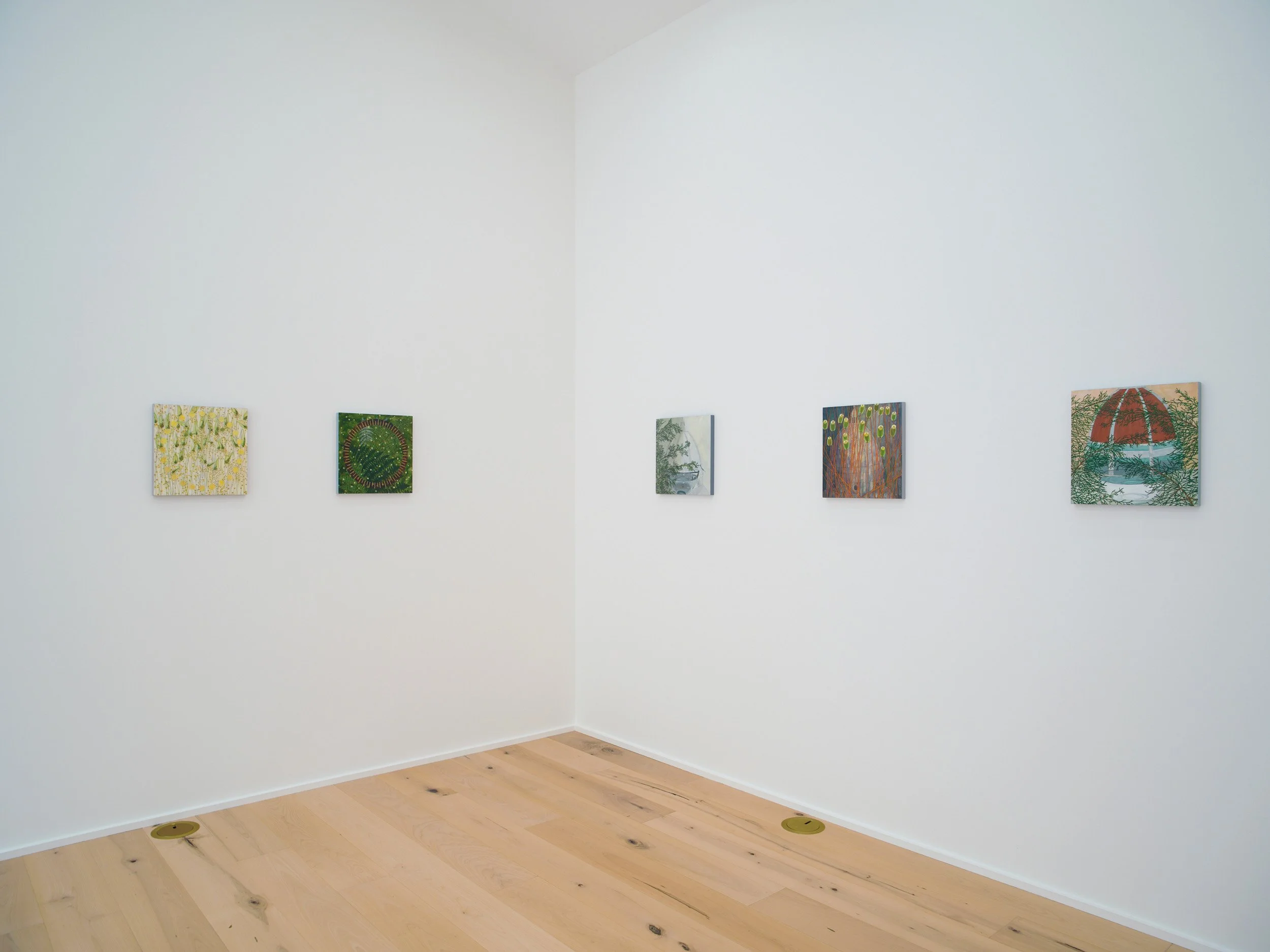 A white art gallery wall displaying seven colorful paintings in a row, with a wooden floor and small round vents on the floor.
