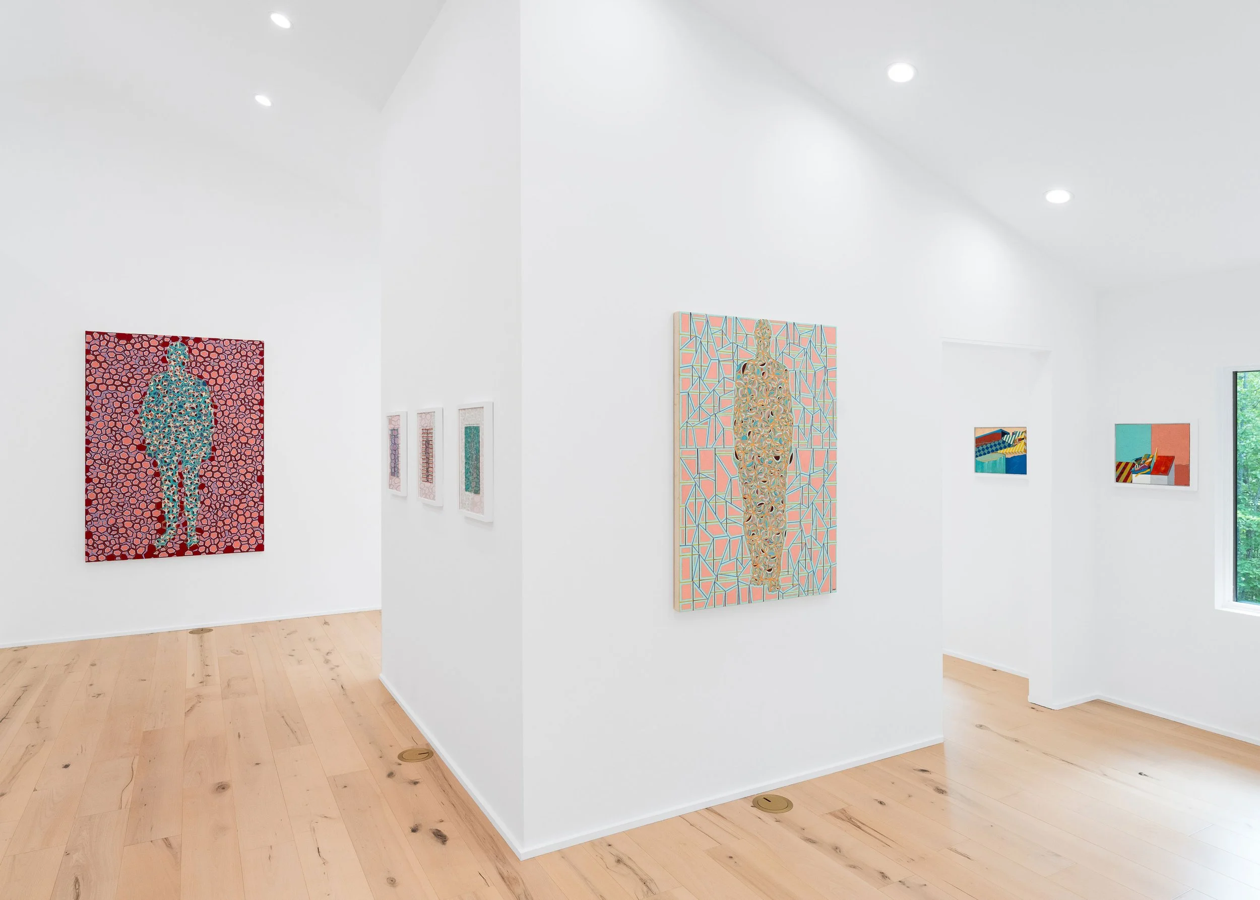 Art gallery with colorful, abstract portrait paintings on white walls and wooden floors.