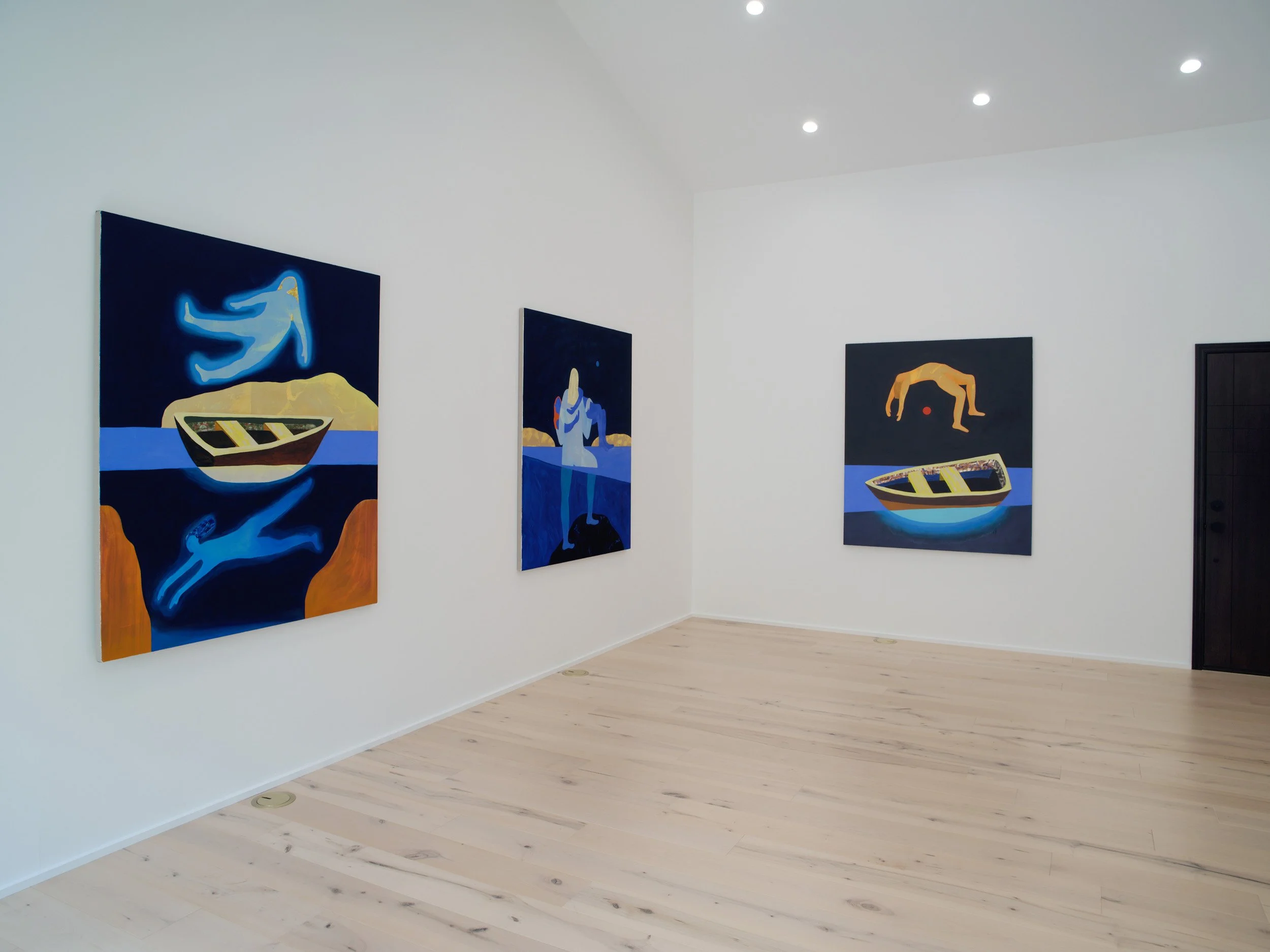 Gallery wall featuring three modern paintings with abstract figures and boat scenes, inside a bright room with white walls and light wood flooring.