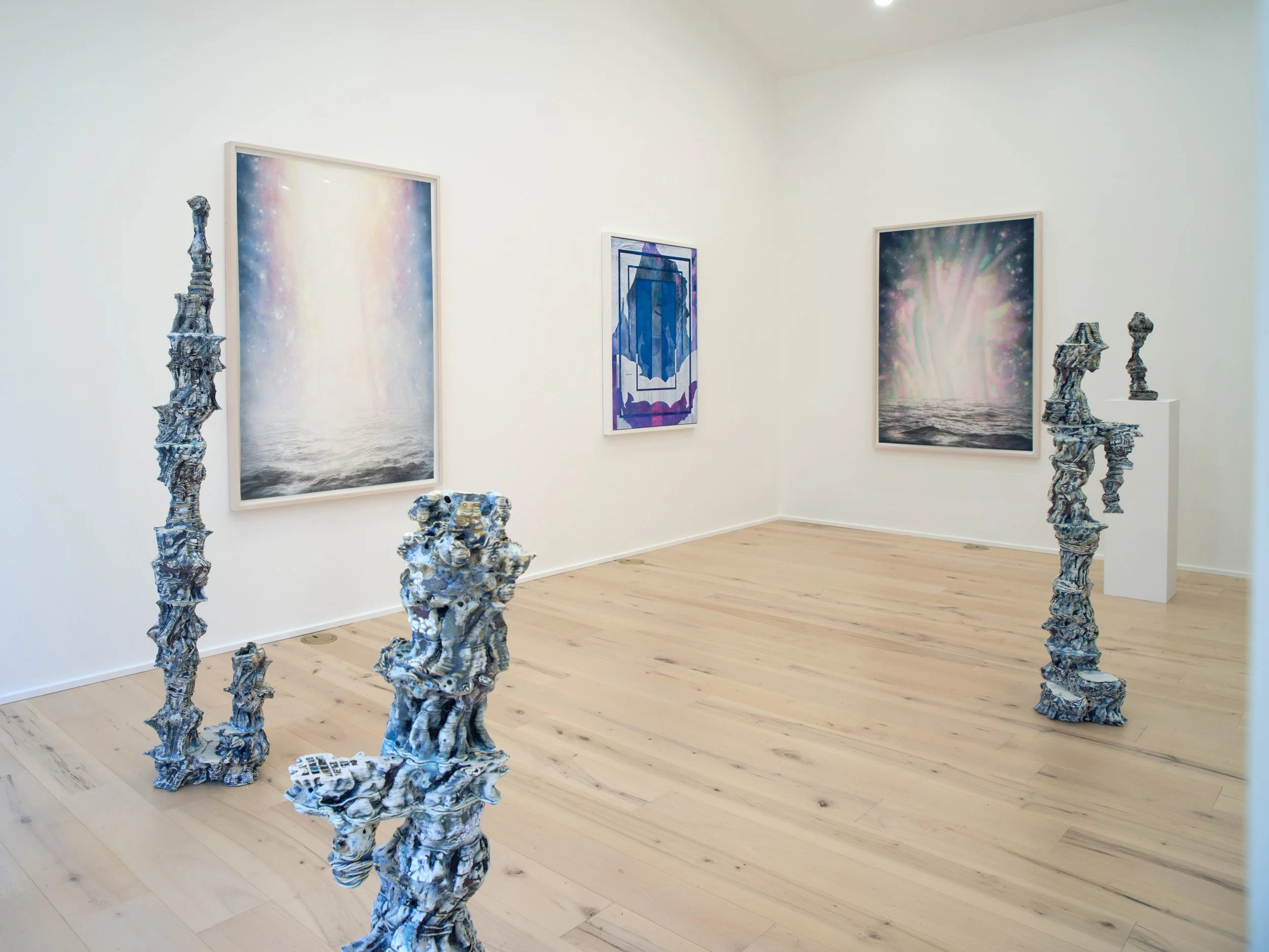 Art gallery exhibit featuring abstract ocean-themed paintings and eco-friendly sculptures made from recycled materials resembling coral and sea creatures.