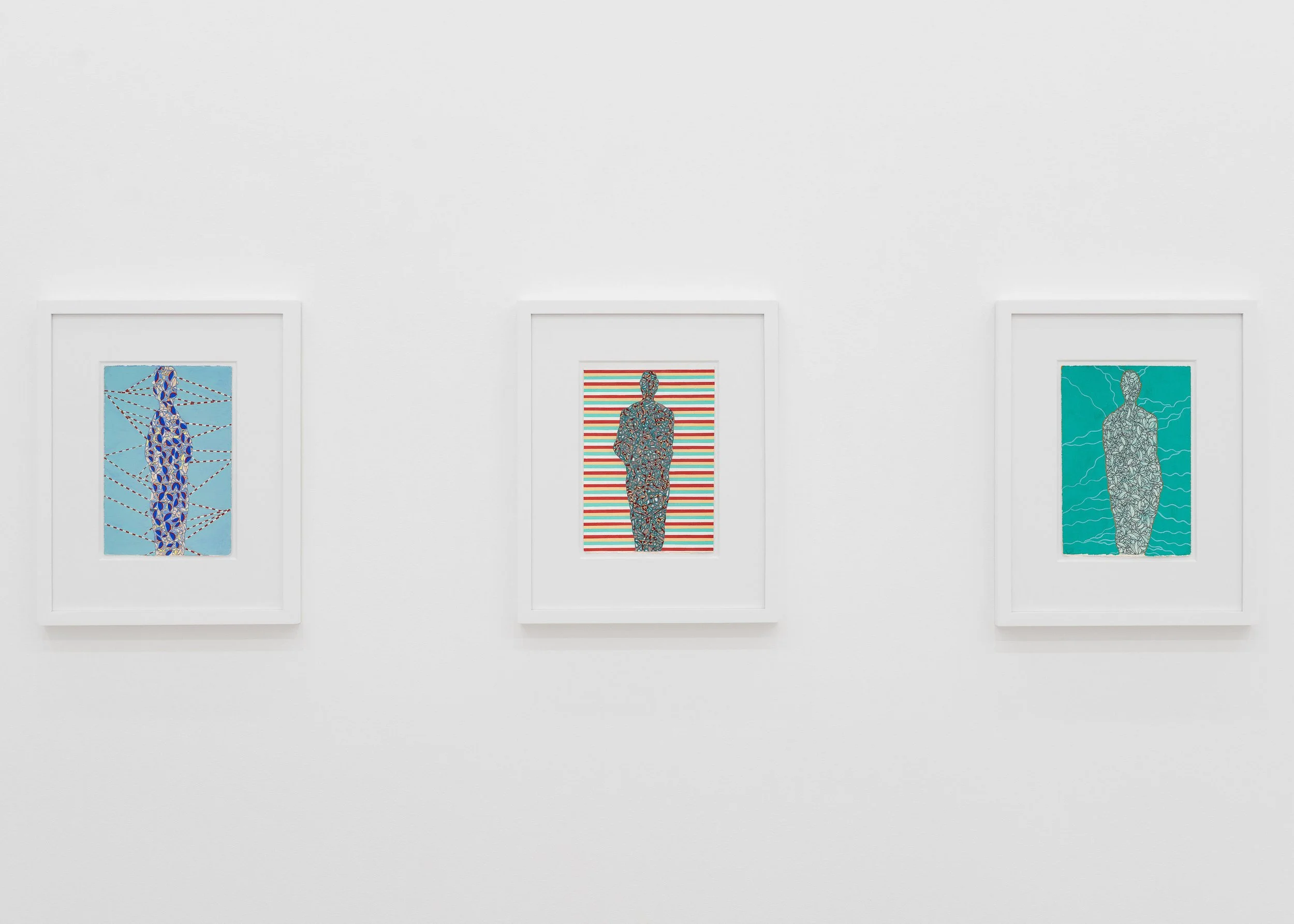 Three framed artworks depicting stylized human figures in detailed patterns, hung on a white gallery wall.