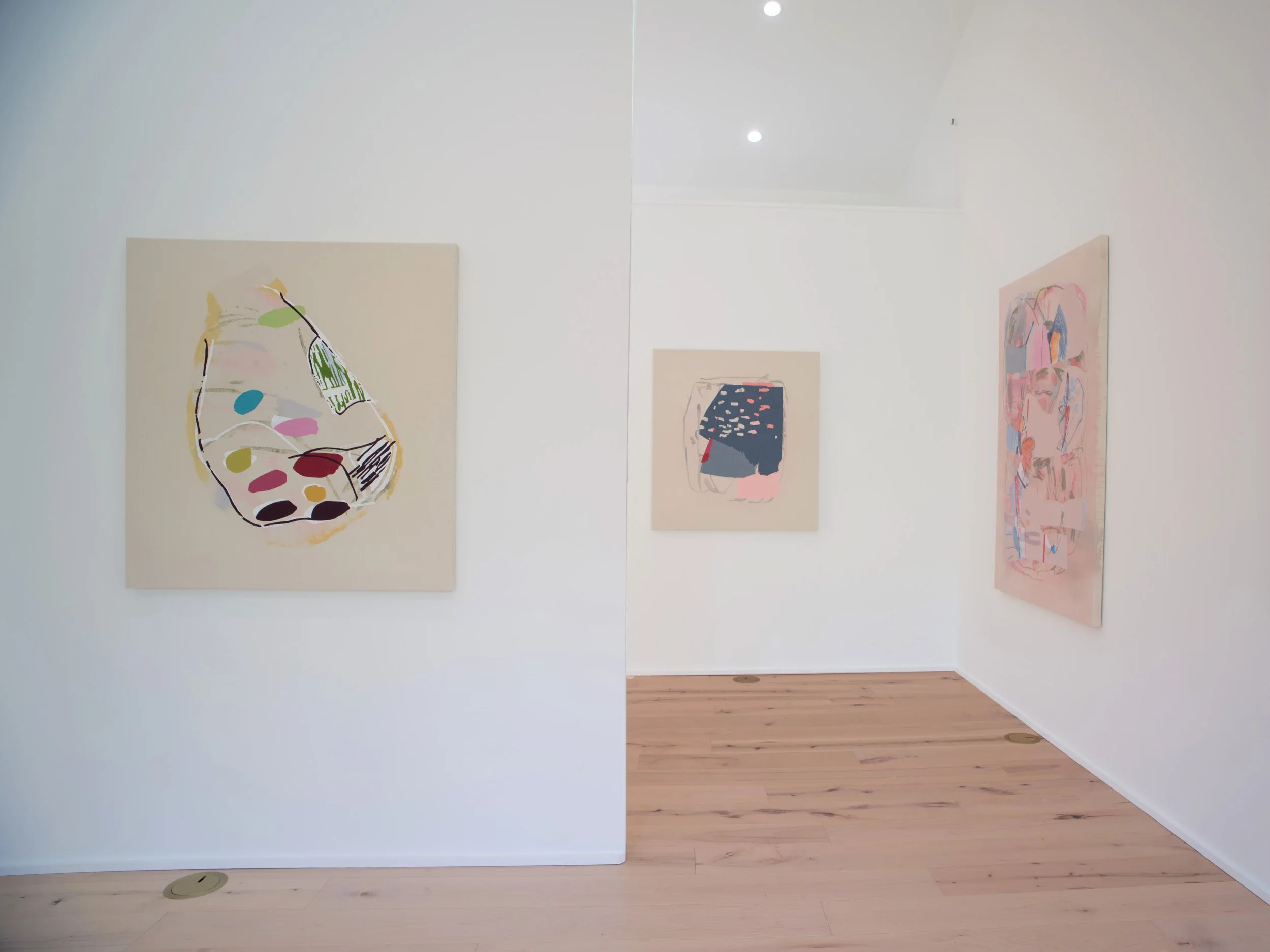 Art gallery wall with abstract paintings showing various shapes and colors.