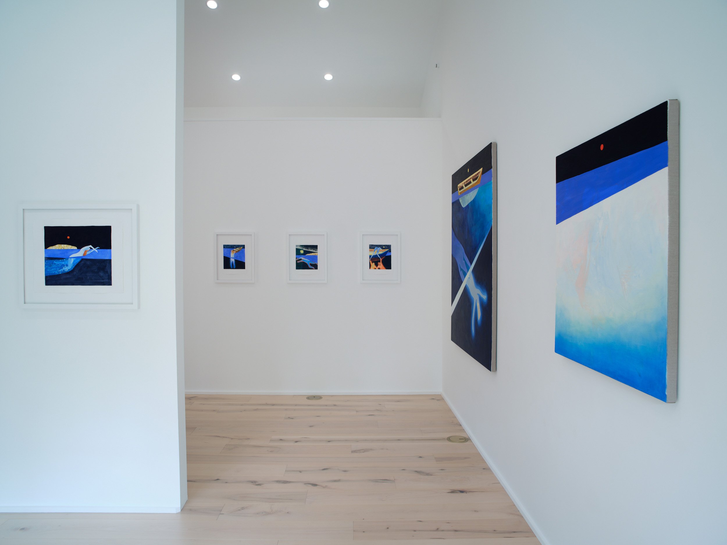 Art gallery with abstract paintings on white walls, wooden floor, and ceiling with three ceiling lights.