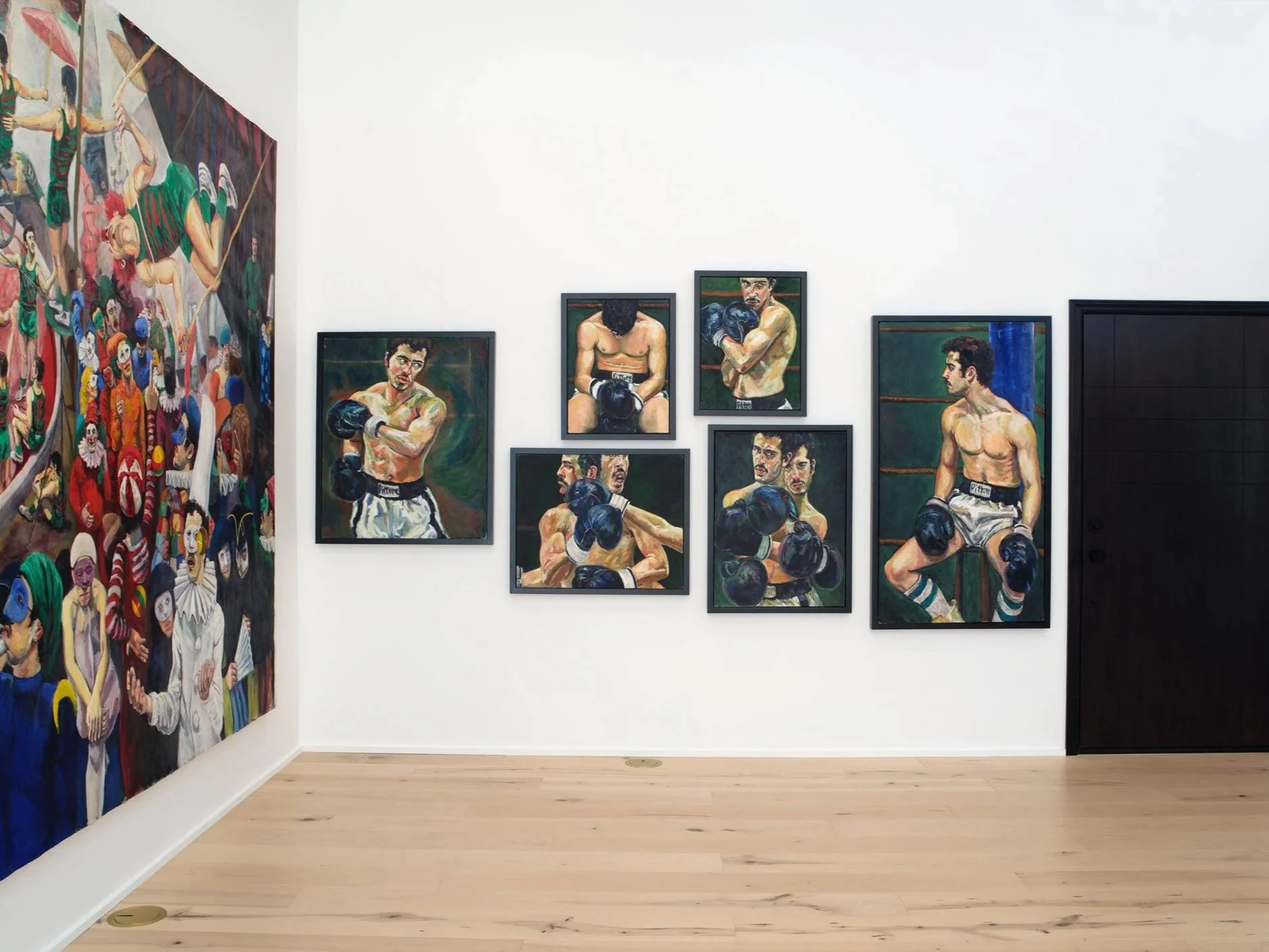 Art gallery featuring colorful paintings of clowns on the left and boxing portraits on the right wall.