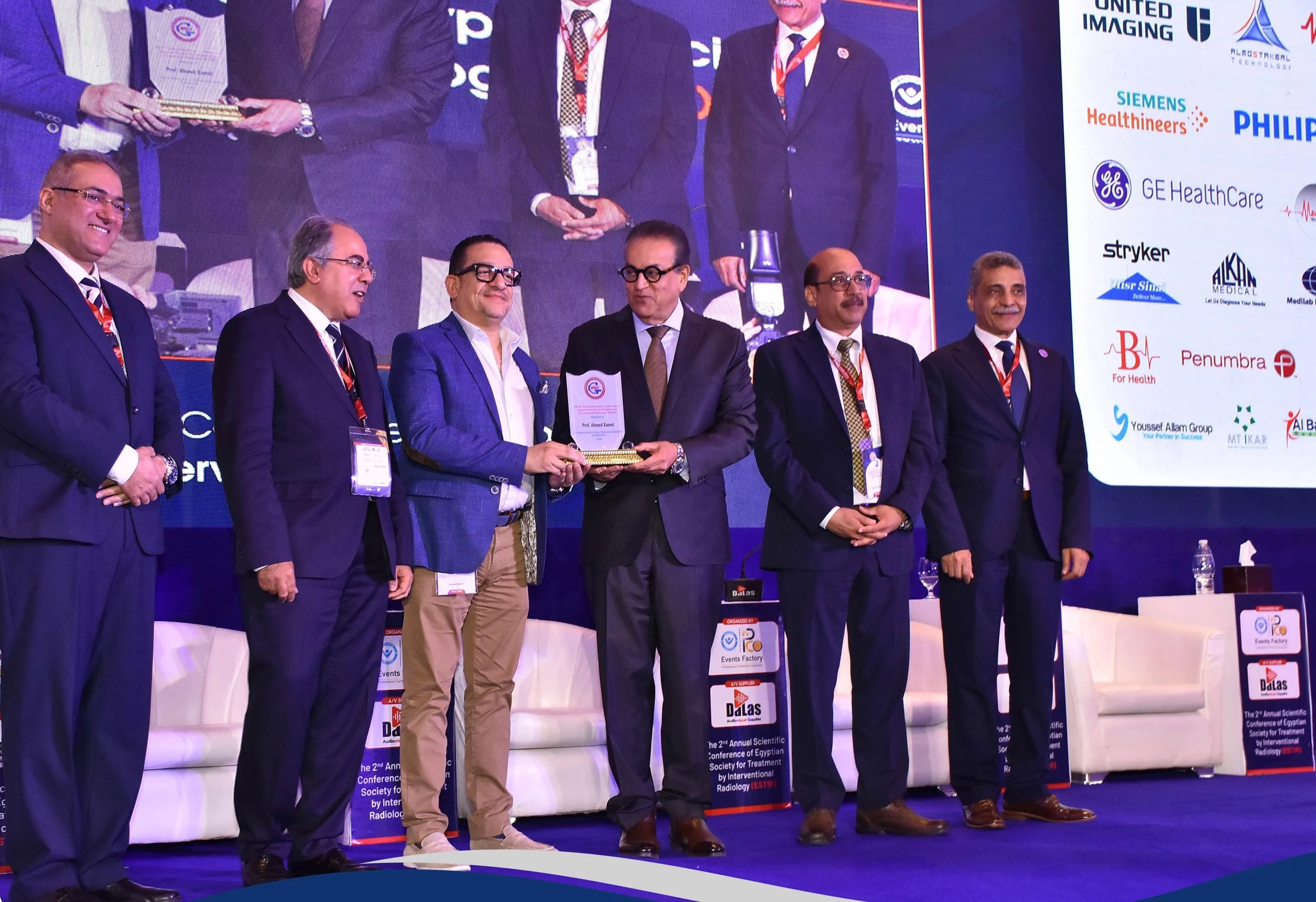 Ahmed Kamel receiving an award on stage during an official ceremony at the first ESTIR conference in May 2026, presented by Ministry of Health representative Khaled Abdel Ghaffar