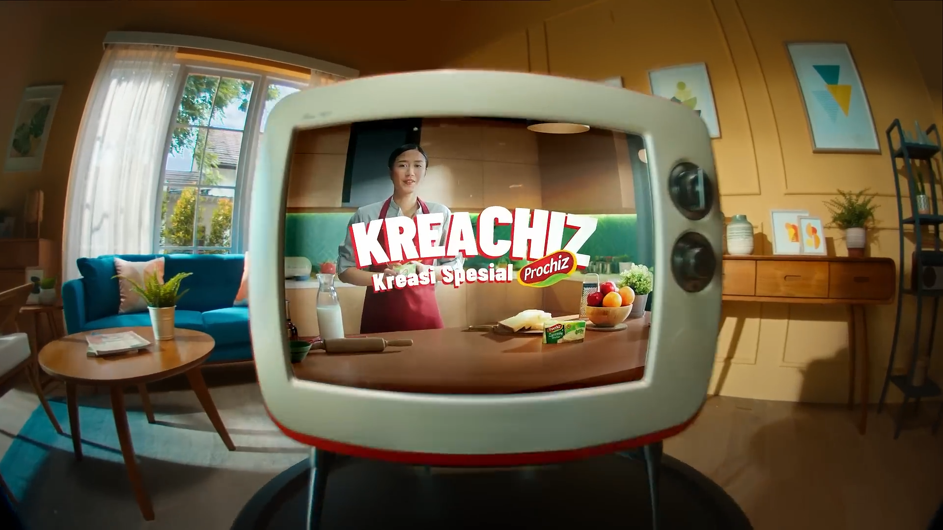 A woman in an apron is cooking or preparing food in a kitchen, seen through the lens of a vintage television set placed on a wooden table in a cozy, brightly lit living room with modern decor.