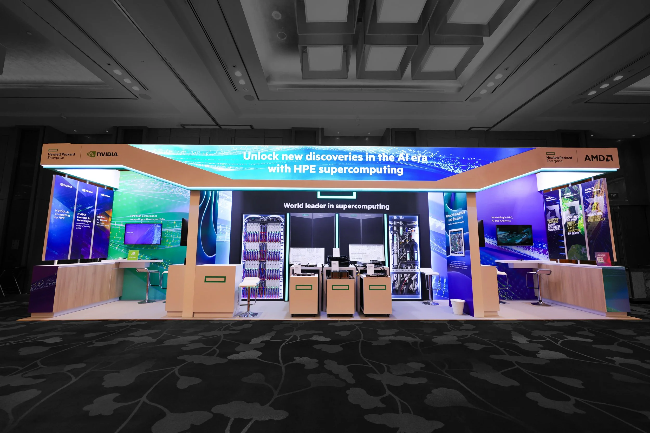 Exhibition booth promoting AI technology with banners from Hewlett Packard Enterprise, Nvidia, and AMD, featuring displays and servers for AI and supercomputing.