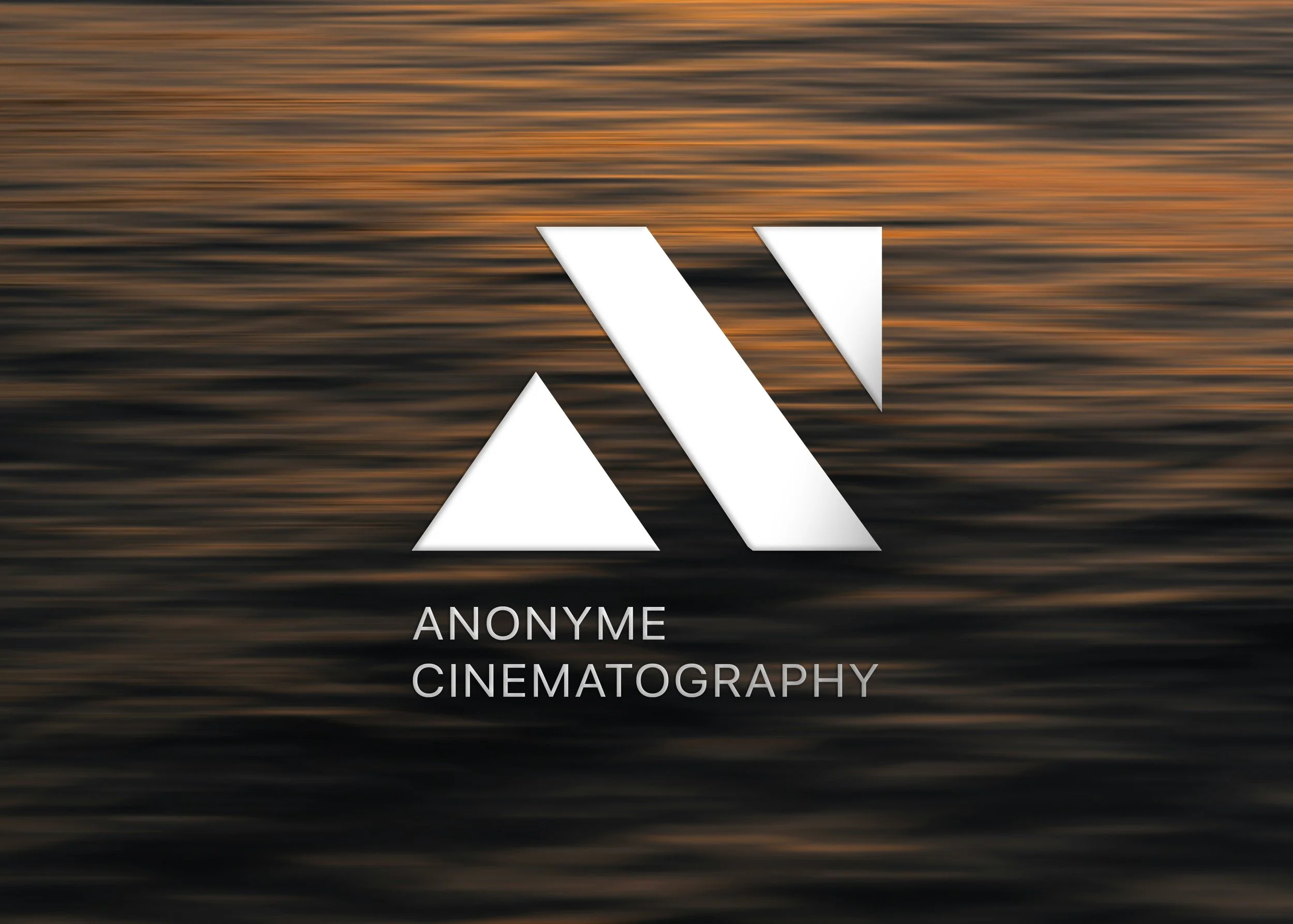 Abstract blurred background with streaks of orange, black, and gray resembling a sunset over water, overlaid with white geometric shapes and text reading "Anonymous Cinematography."