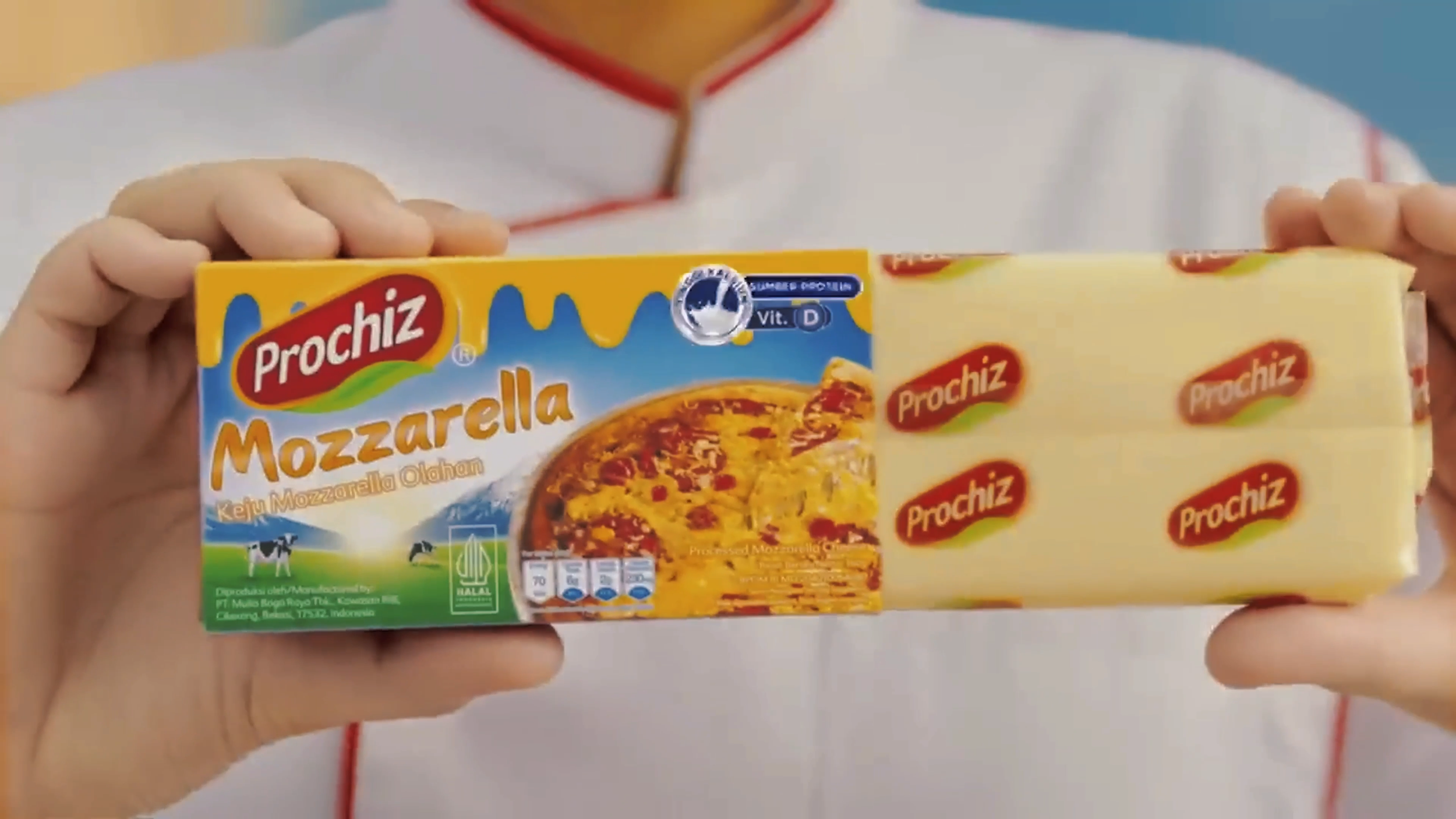 Person holding a package of Prochiz mozzarella cheese, with the logo and cheese image visible.
