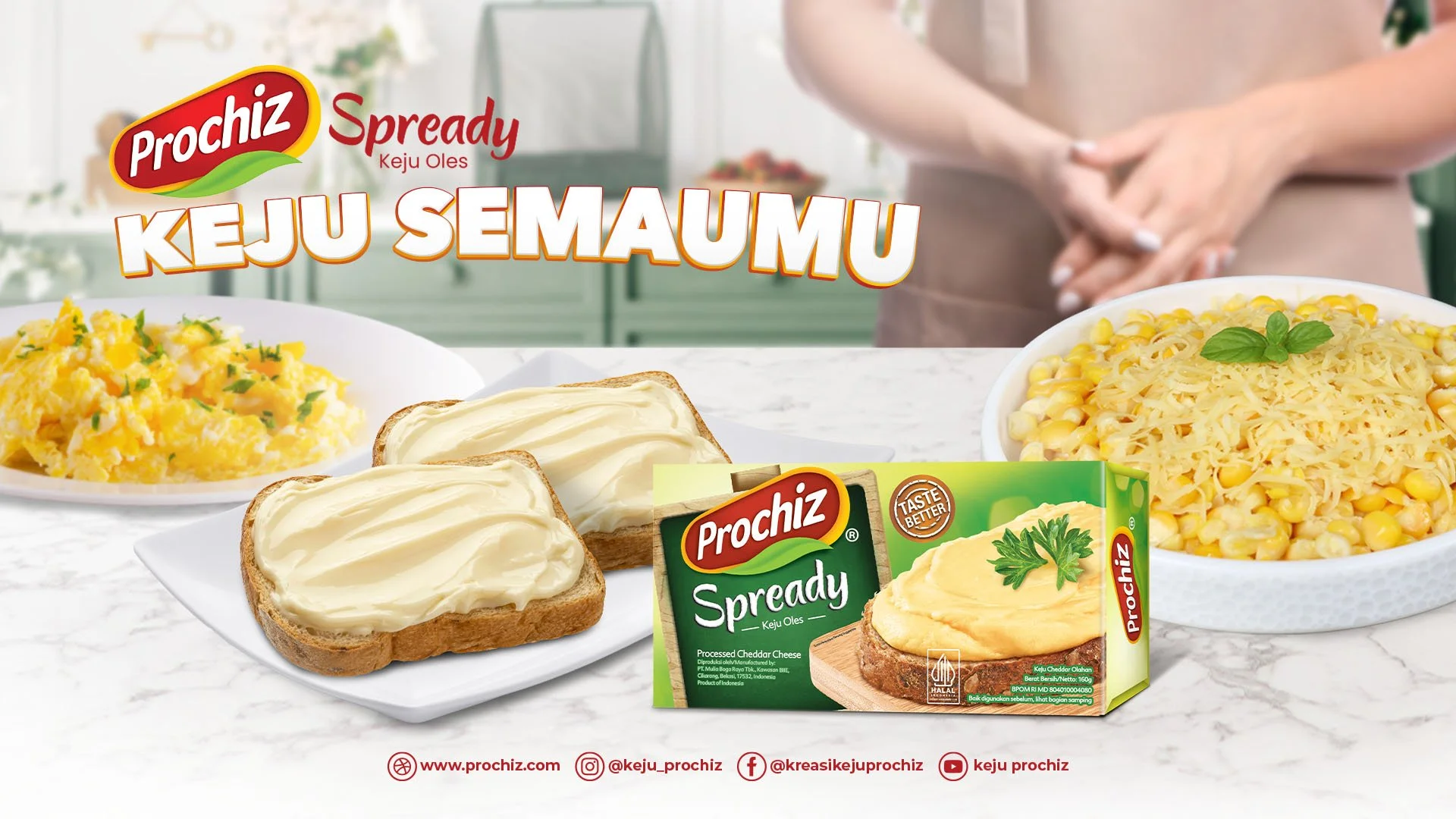 A breakfast scene featuring slices of bread with cheese spread, a bowl of scrambled eggs, and a bowl of corn with shredded cheese, with a package of Prochiz Spready processed cheddar cheese in the foreground. The background includes a person with crossed arms and a kitchen setting.