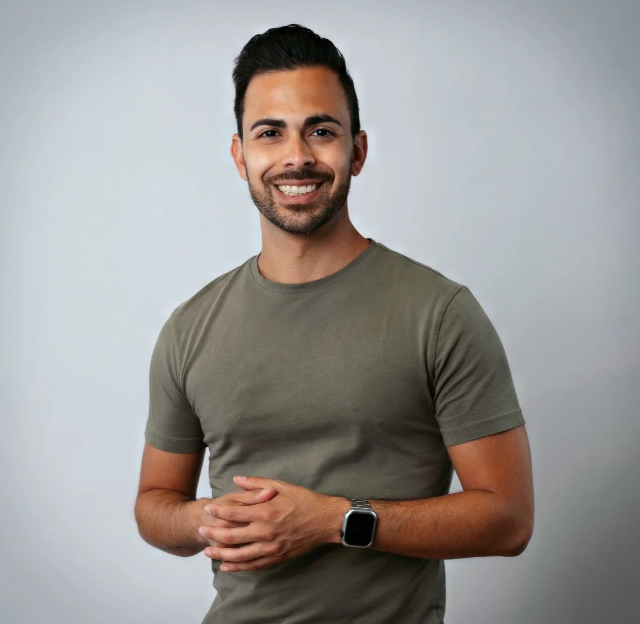 Smiling man in olive t-shirt against gray background: Danny Morales — Gay and Bisexual Men's Dating and Relationship Coach