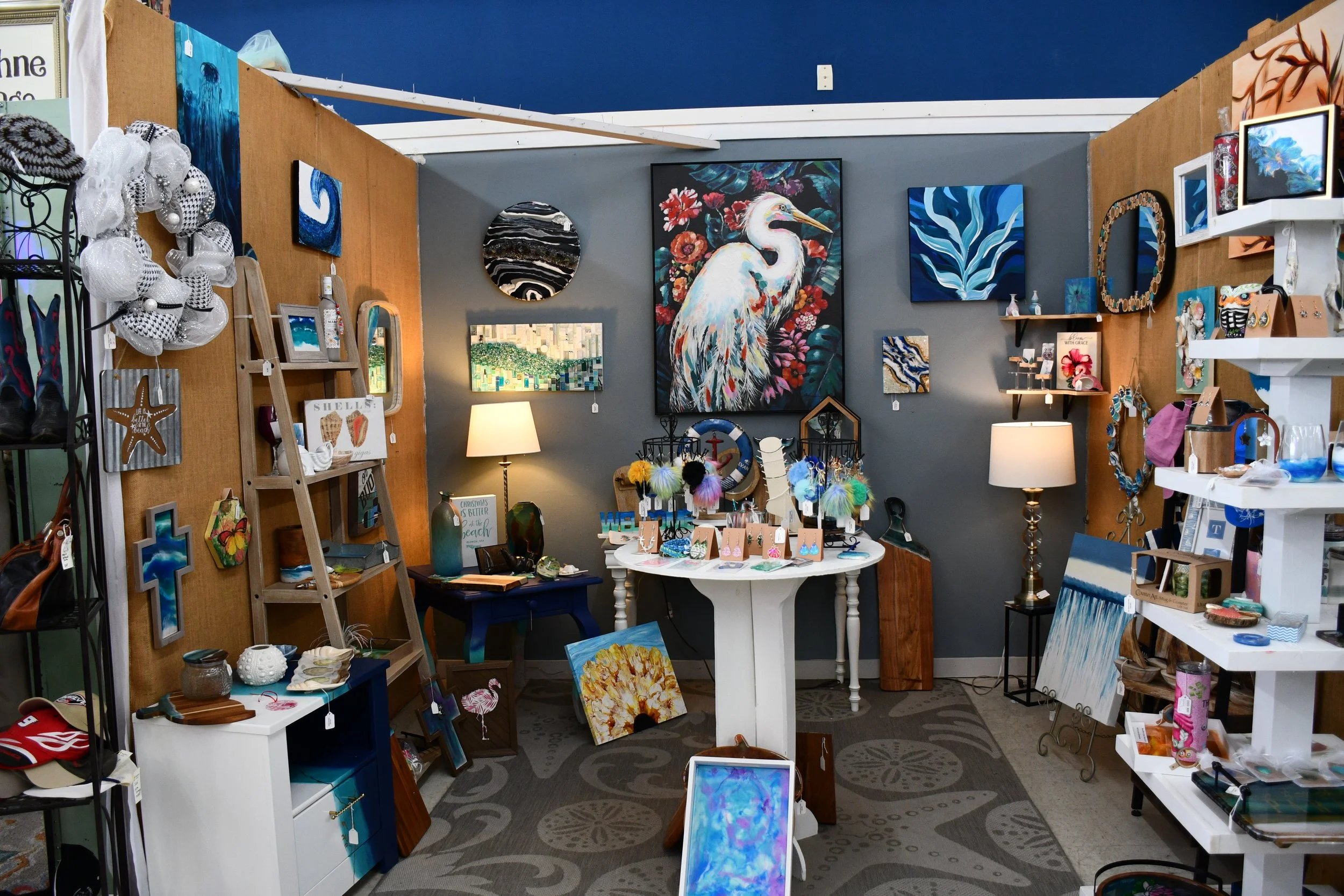 Interior of an art store with paintings and crafts displayed on walls and shelves.