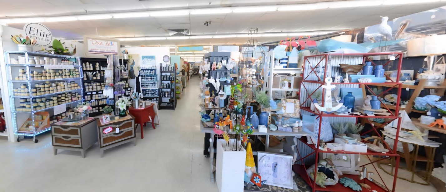 Interior of a home decor store with shelves filled with various vases, sculptures, and decorative items, including ceramic and glass pieces, with an aisle running through the middle.