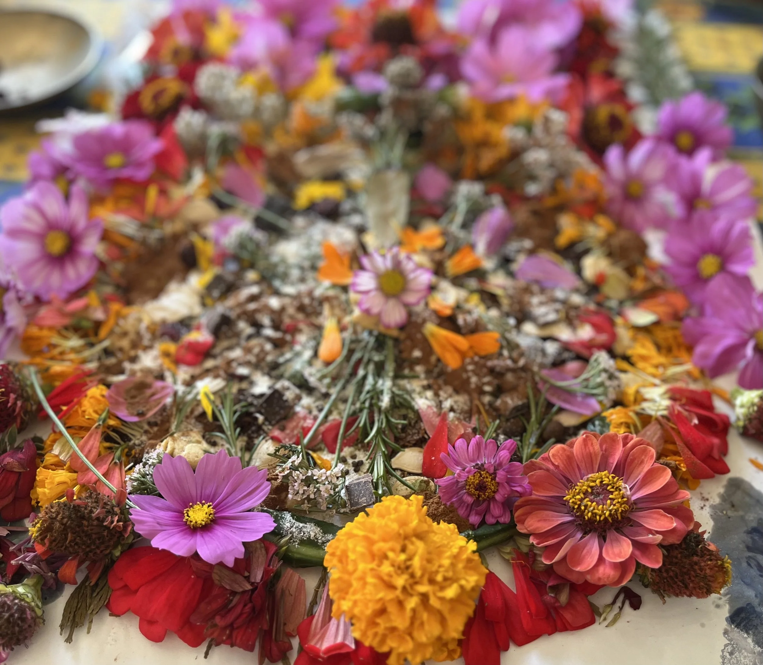 Colorful flower petals and marigolds arranged on a surface, likely for a cultural or religious decoration.