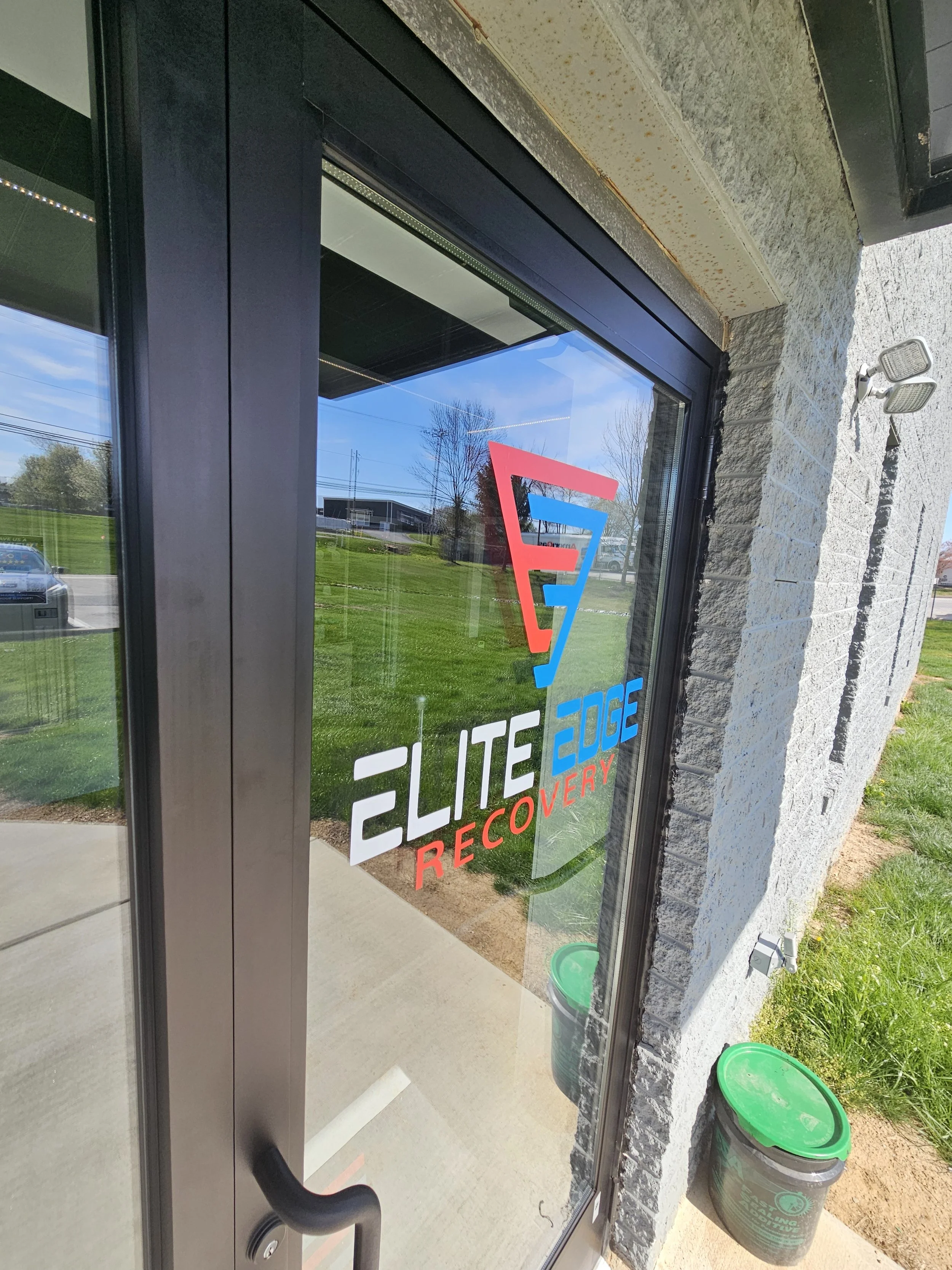 A front door to a store with the Elite Edge Recovery logo on the front located near Berwyn, PA.