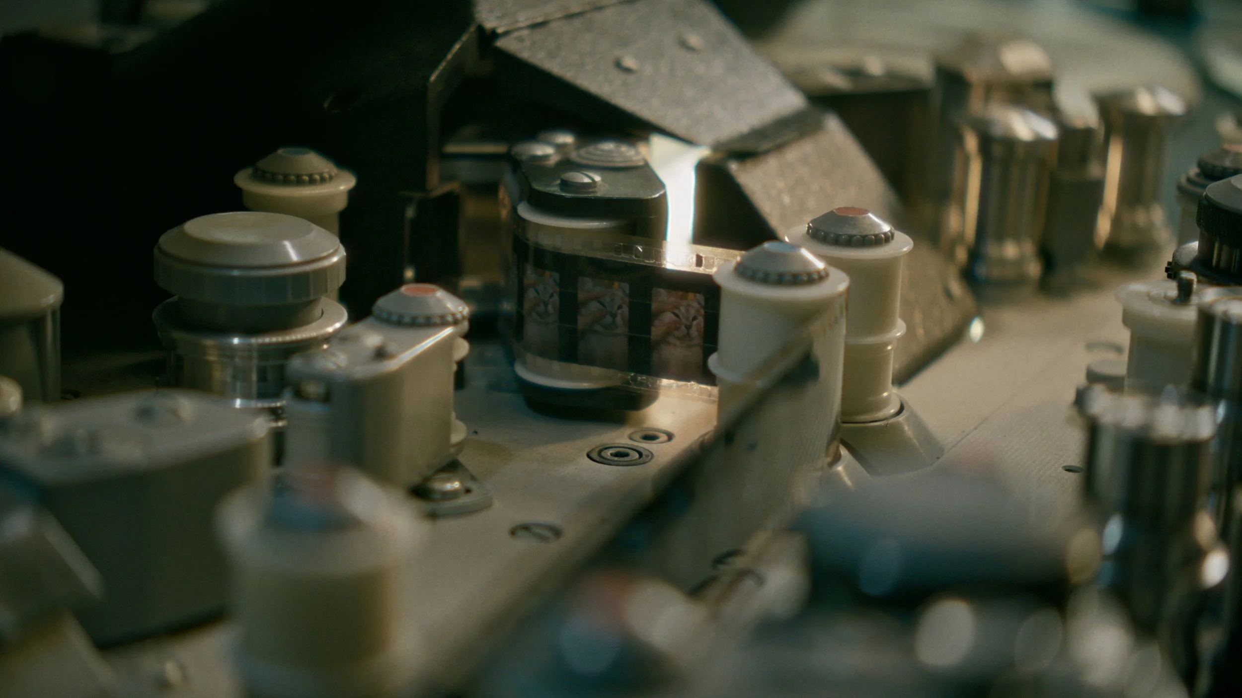 Nahaufnahme eines Kameas mit mehreren Komponenten, Teile aus Metall und Kunststoff, möglicherweise Relais oder elektronische Bauteile, auf einer technischen Leiterplatte