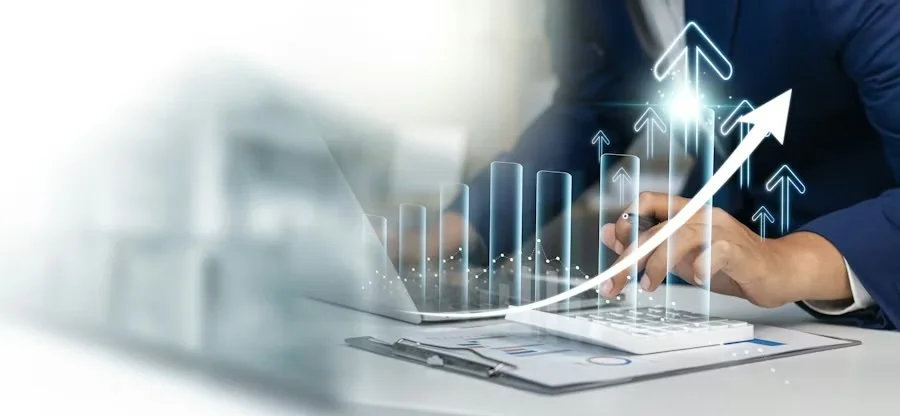 Close-up of a person in business attire using a laptop, with digital graphs and upward arrows illustrating growth and progress.