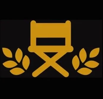 A gold-colored birthday cake with a rectangle top and a cross-shaped base, flanked by two laurel wreaths on a black background.