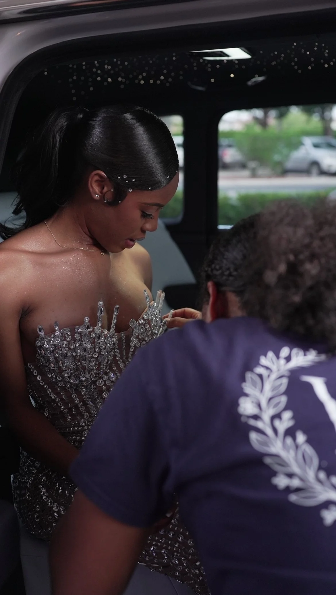 Helen Charlton helping adjust a young woman's outfit as she arrives at a prom send-off event.