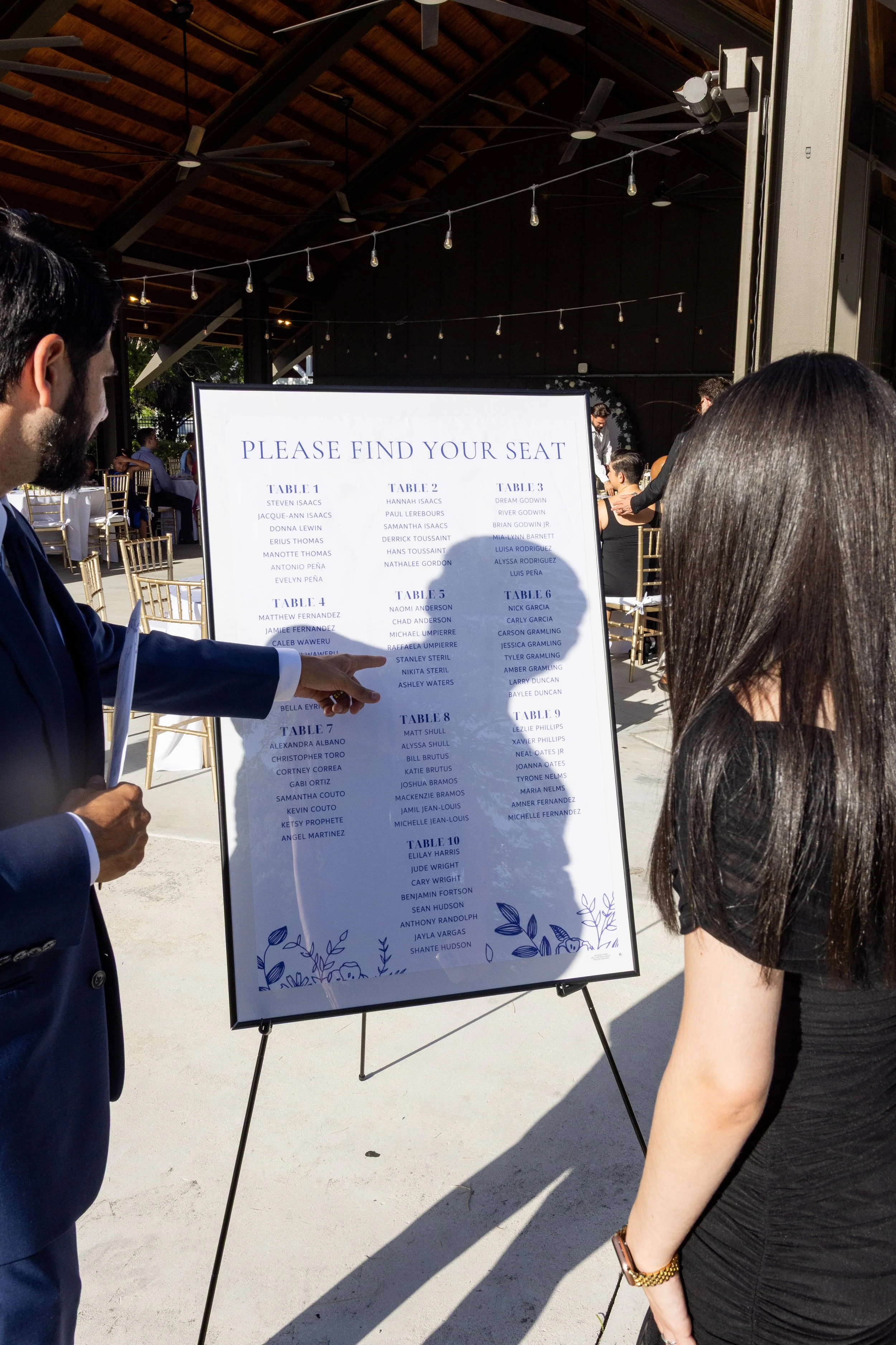 Two guests checking the seating chart as they enter the outdoor venue.
