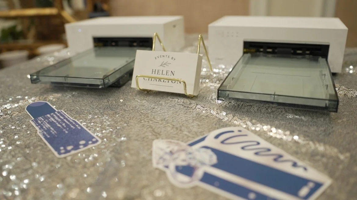 Sticker printers for a Mother's Day celebration with Events by Helen business cards on display.