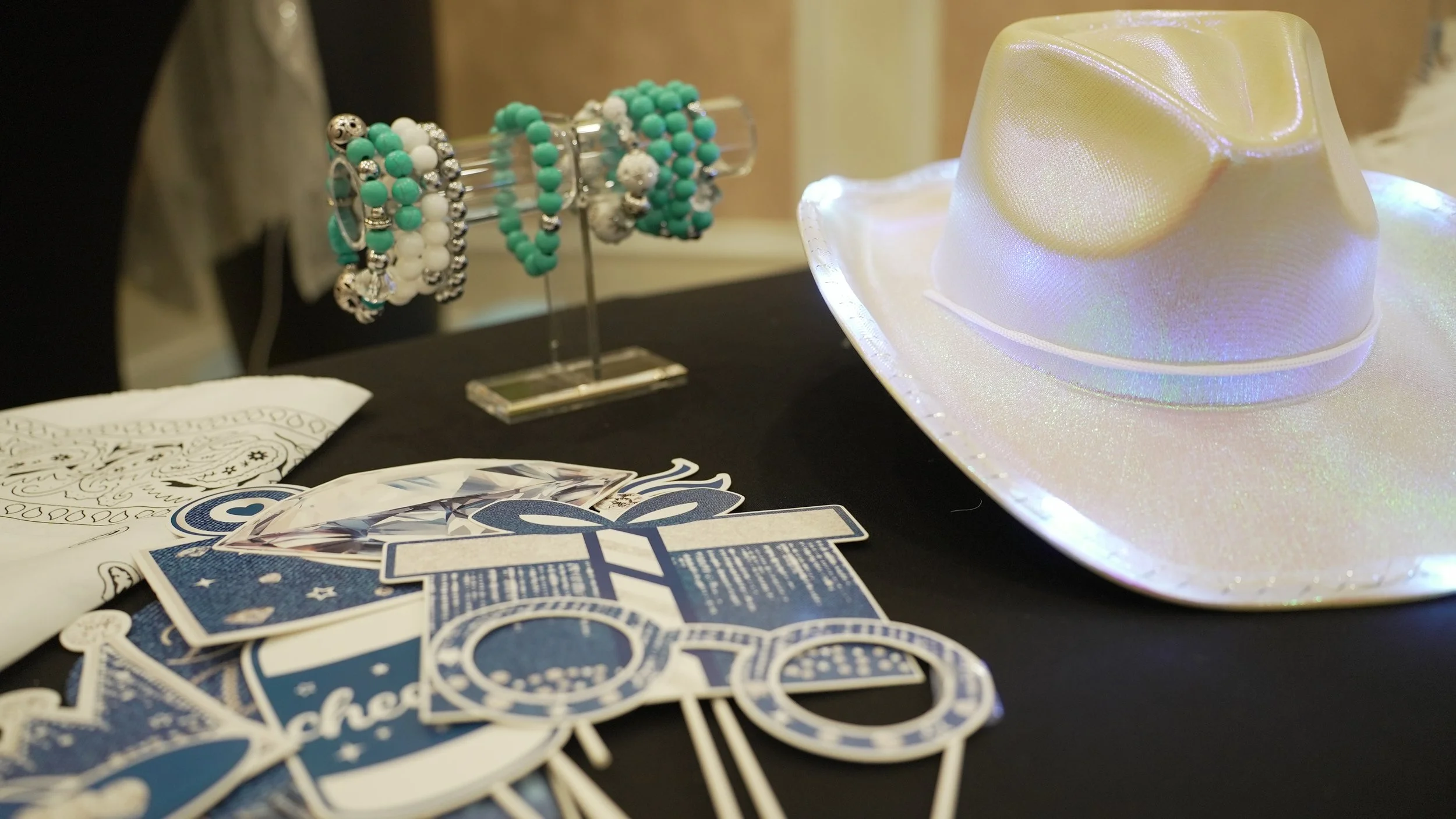 Mother's Day setup featuring party favors, a cowgirl hat, and a bracelet stand.