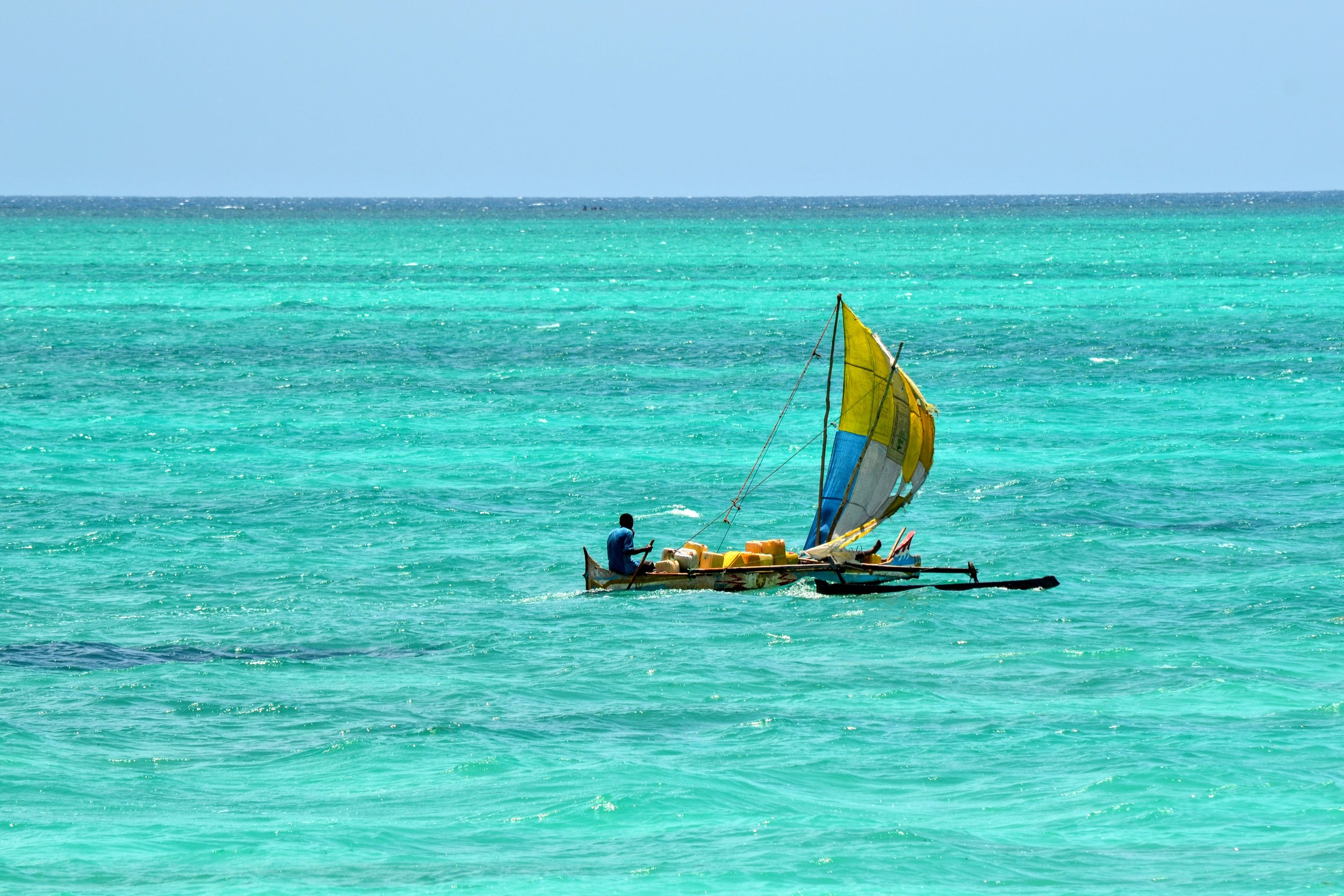 A man transporting water jugs by boat in Toliara, Madagascar. November 2022. 