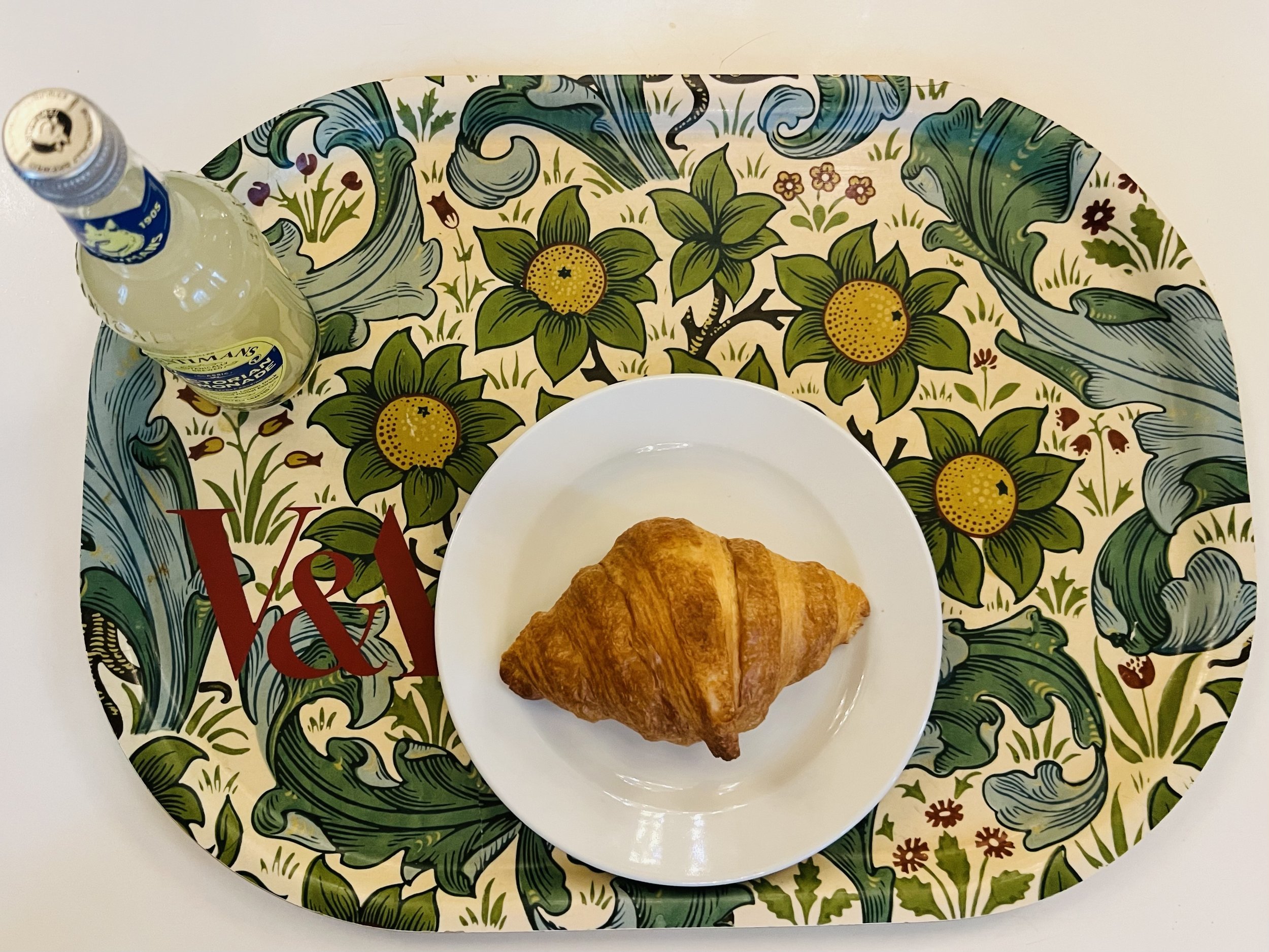 A croissant and a fizzy lemonade and the Victoria & Albert Museum in London. I like the colors. The café is beautiful. March 2024. 