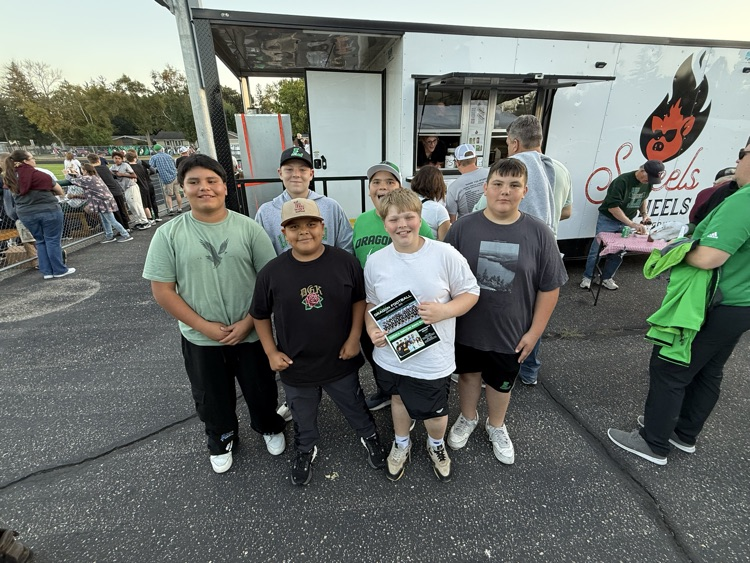 Group of young boys standing at an outdoor event.