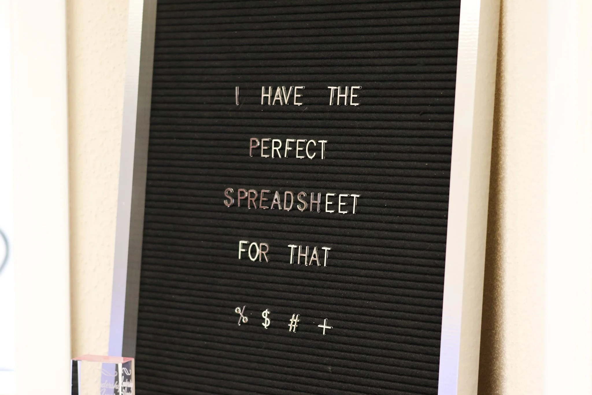 Black letter board with white and pink letters reading "I HAVE THE PERFECT SPREADSHEET FOR THAT".