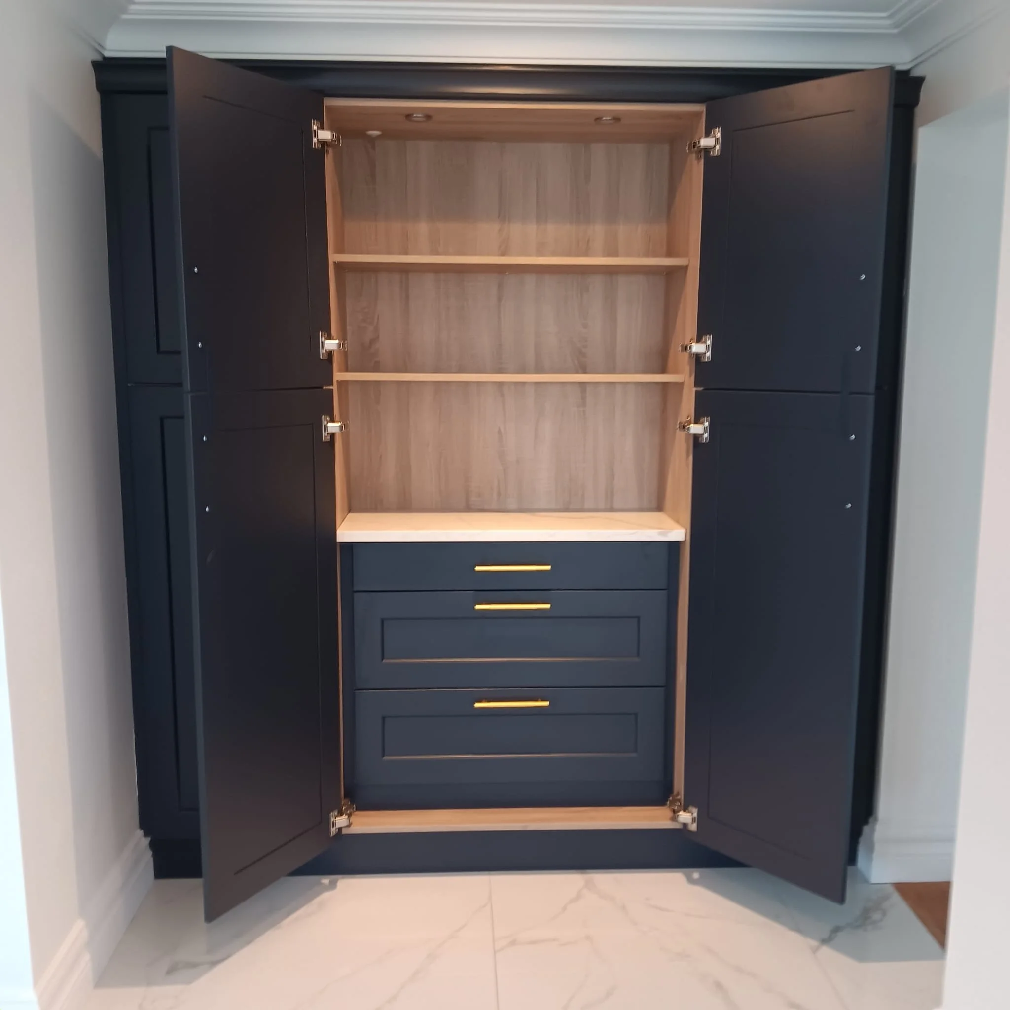 A black and wooden cabinet with open doors showing empty shelves inside, placed against a white wall.