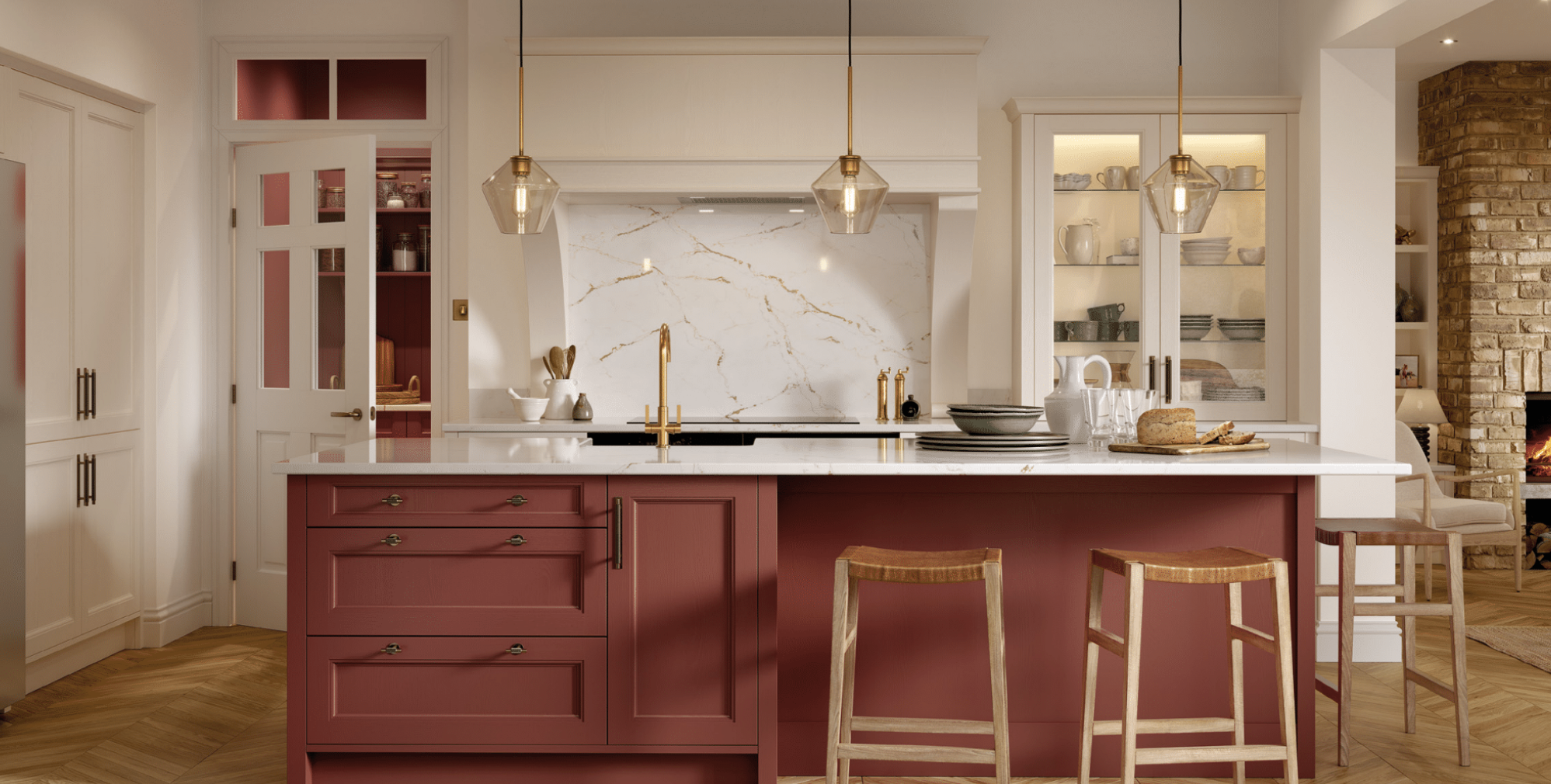 A modern kitchen with a red island, white countertop, brass fixtures, glass-front cabinets, a marble backsplash, and a brick fireplace.