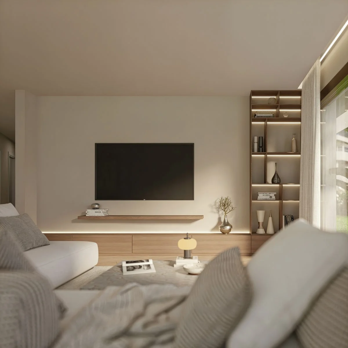 Interno di un soggiorno moderno con pareti beige, divano beige, e una parete con schermo TV e scaffali decorativi con oggetti di design e libri.