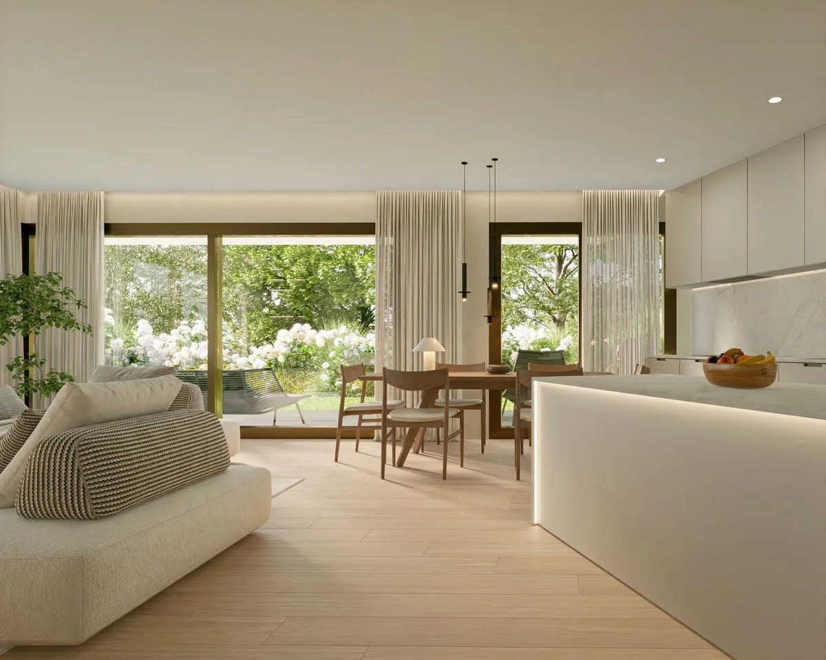 Salotto e zona dining di un appartamento con grandi finestre che affacciano sul giardino, arredi moderni, divano beige, tavolo in legno con sedie, e una cucina con luminoso bancone.
