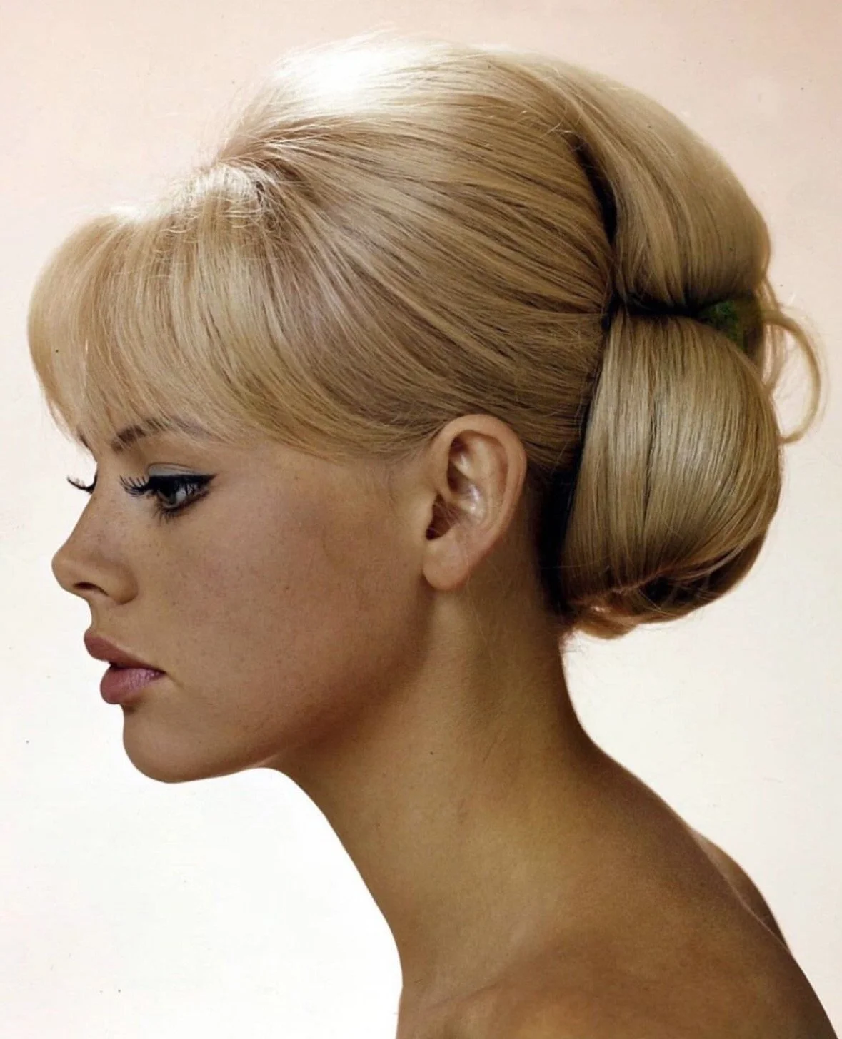 Side profile of a woman with vintage blonde hair styled in an elegant updo.