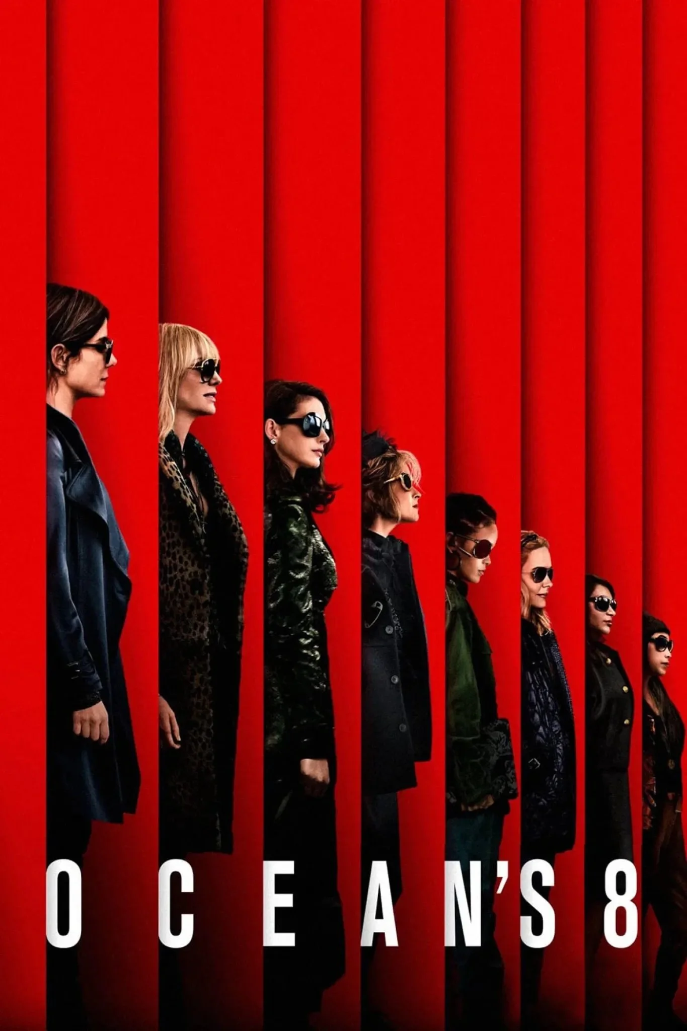 A line of women standing side by side in front of a red background, each wearing sunglasses and stylish jackets, representing the movie poster for Ocean's 8.