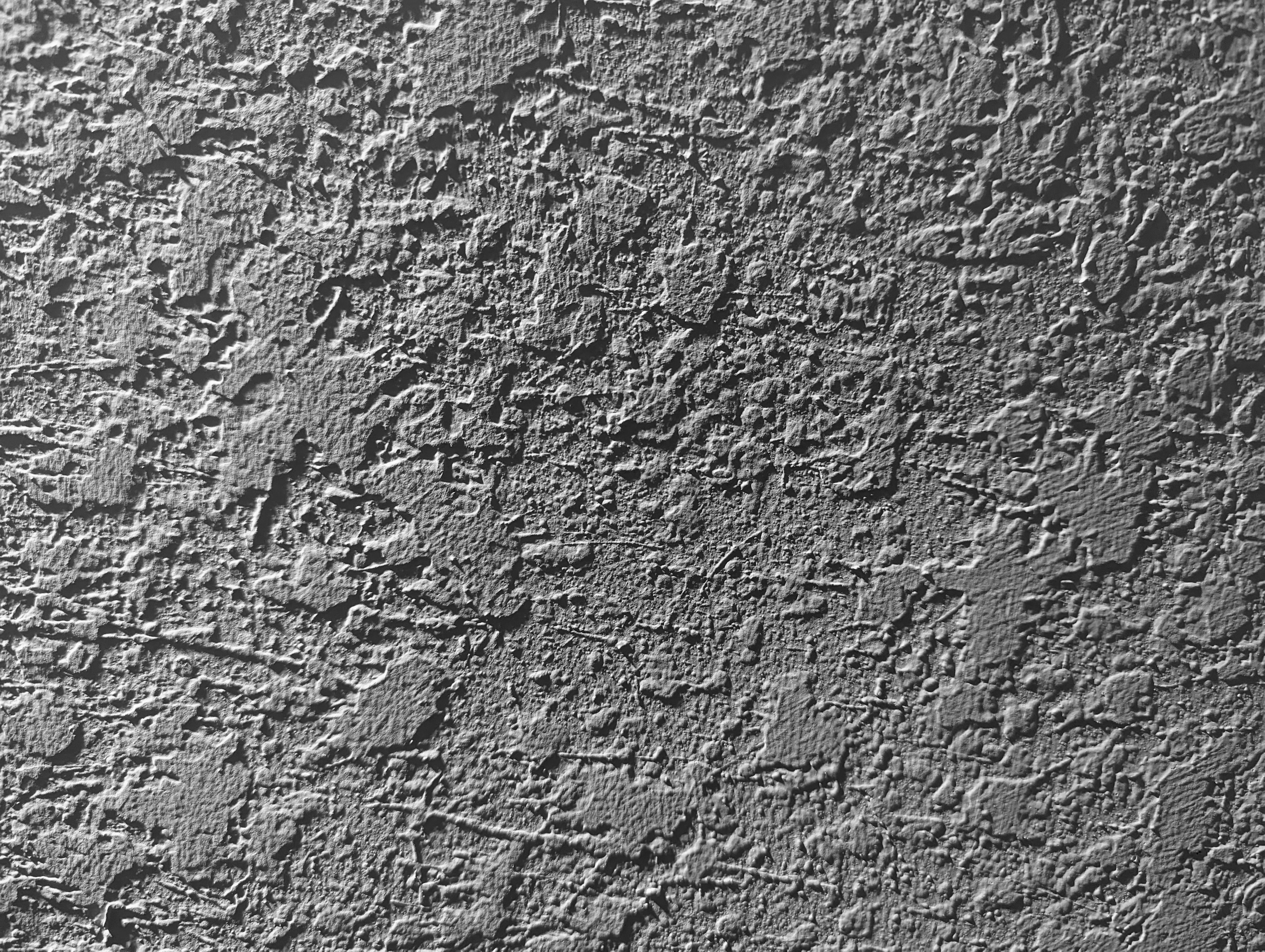 Superficie de pared de textura rugosa y grisásea.