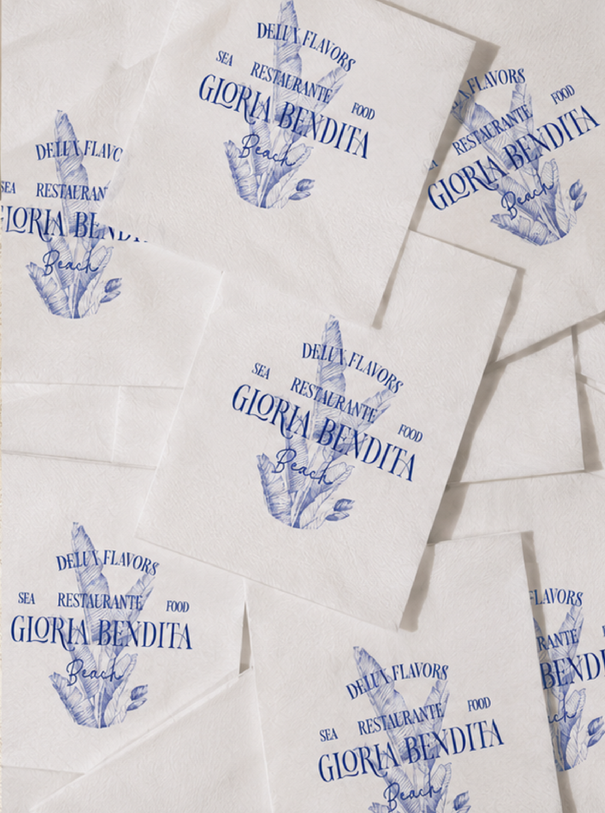 Tarjetas blancas con notas en azul que contienen la inscripción 'Delicious flavors from sea restaurant Gloria Bendita Beach' con un dibujo de un diagrama de orientación en el centro