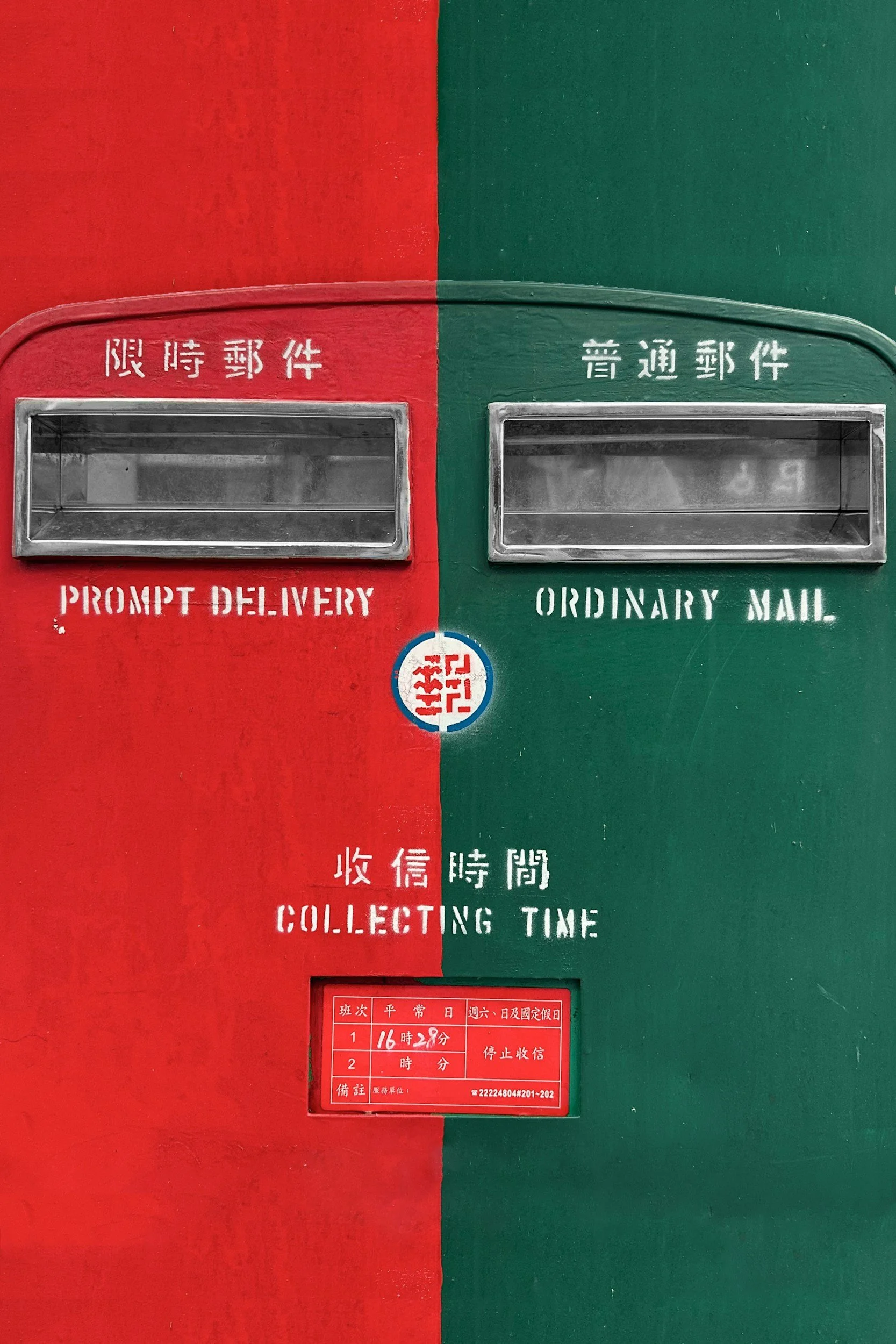 A red and green shared mailbox with labels in Chinese characters, indicating 'Prompt Delivery' on the red side and 'Ordinary Mail' on the green side, with a red collection time schedule below.