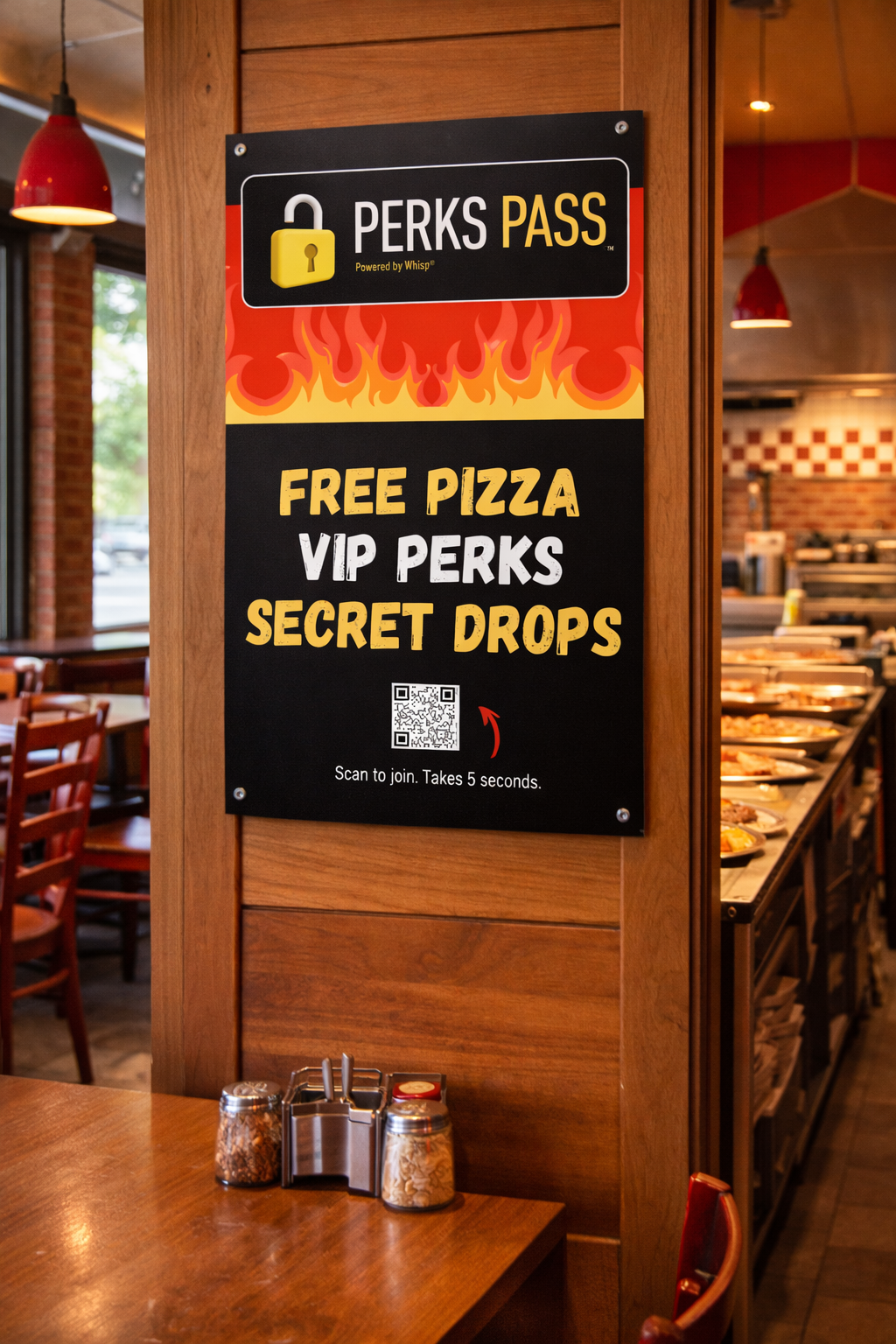 Furniture and a sign inside a restaurant promoting free pizza and VIP perks, with a QR code for joining, and condiment jars on a wooden table.