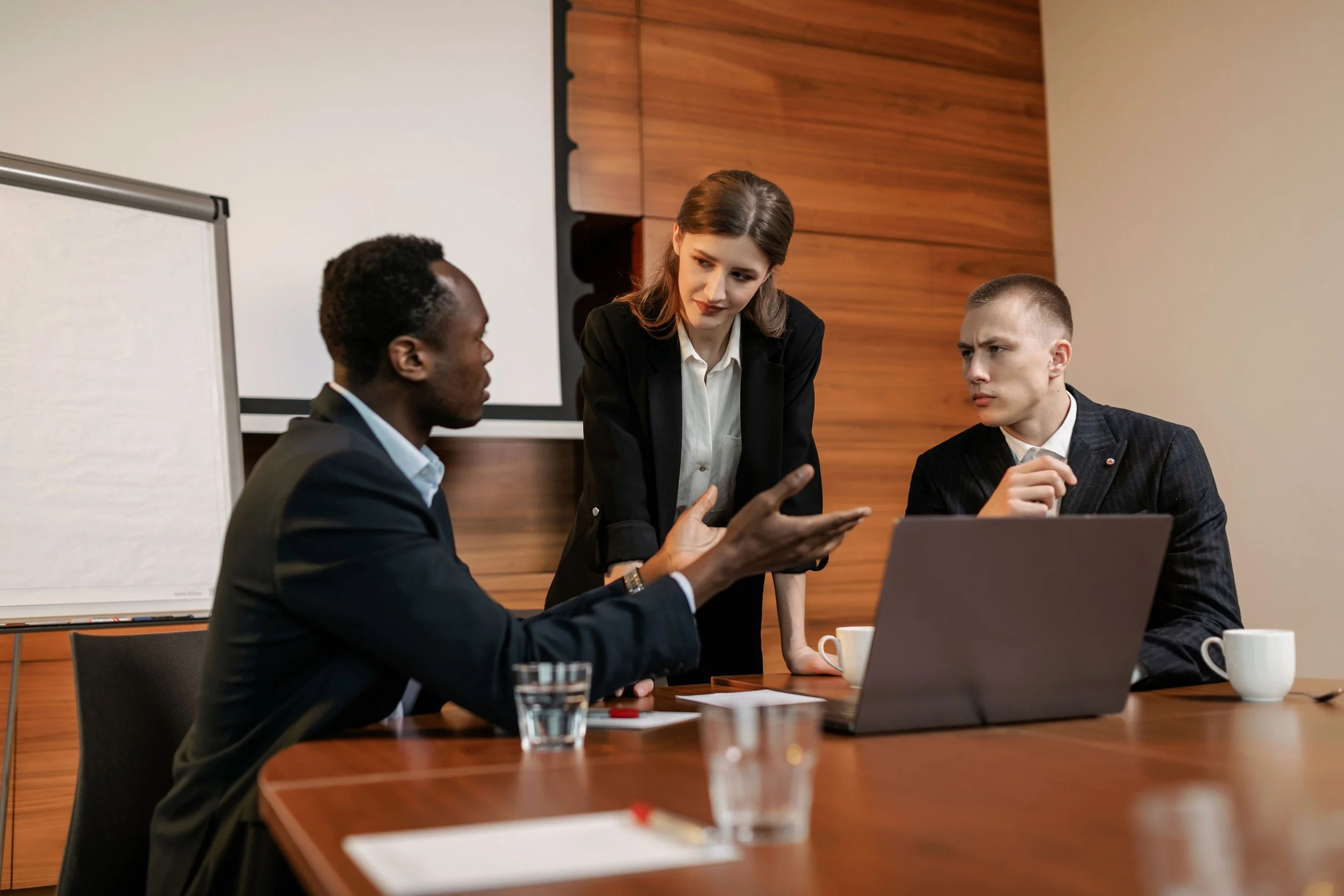 Two employees participating in workplace mediation with a female mediator