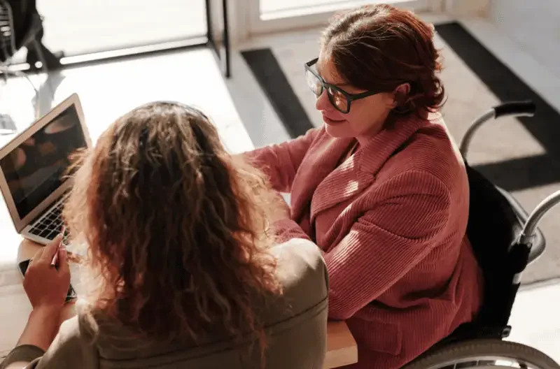 HR professionals discussing employee disability disclosures during a workplace meeting.