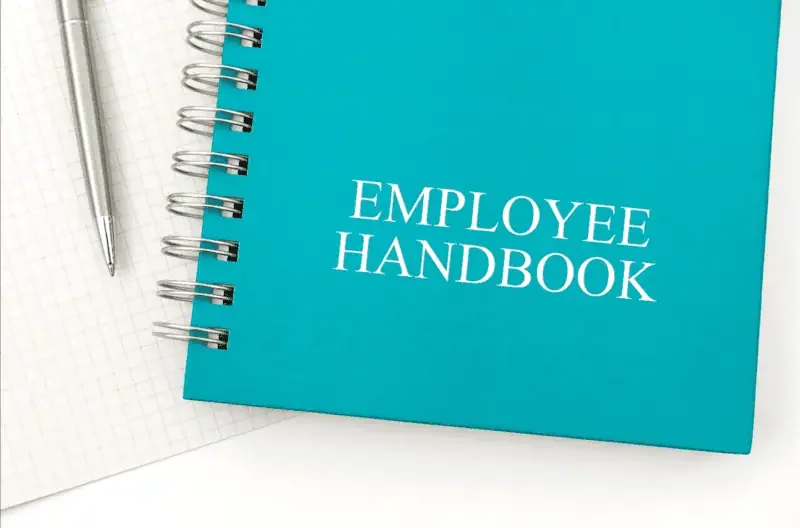 Close-up of an employee handbook and pen on a table
