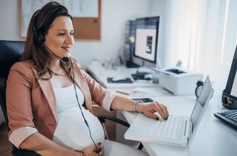 Pregnant employee working at a desk in an office