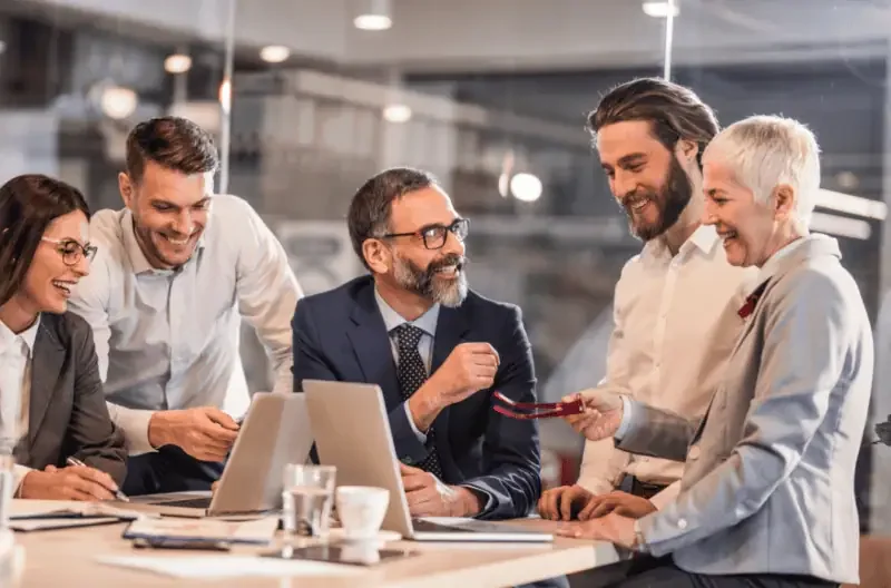 Team members collaborating enthusiastically on a project during a workplace meeting