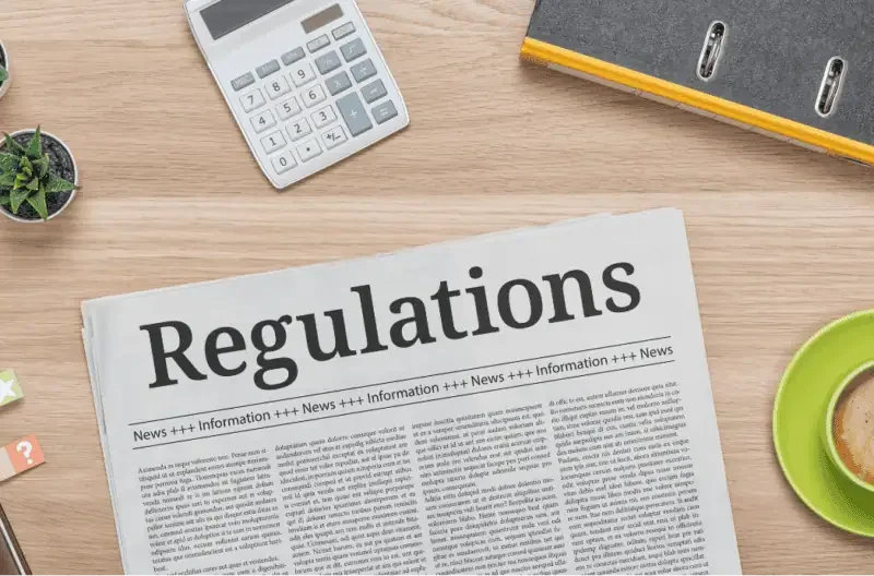 Newspaper on a desk featuring the headline 'Regulations'.
