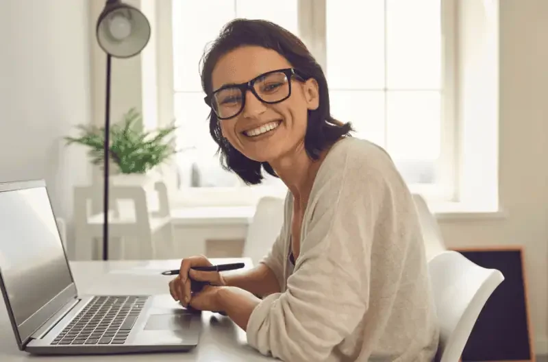 Woman smiling at her desk while working.