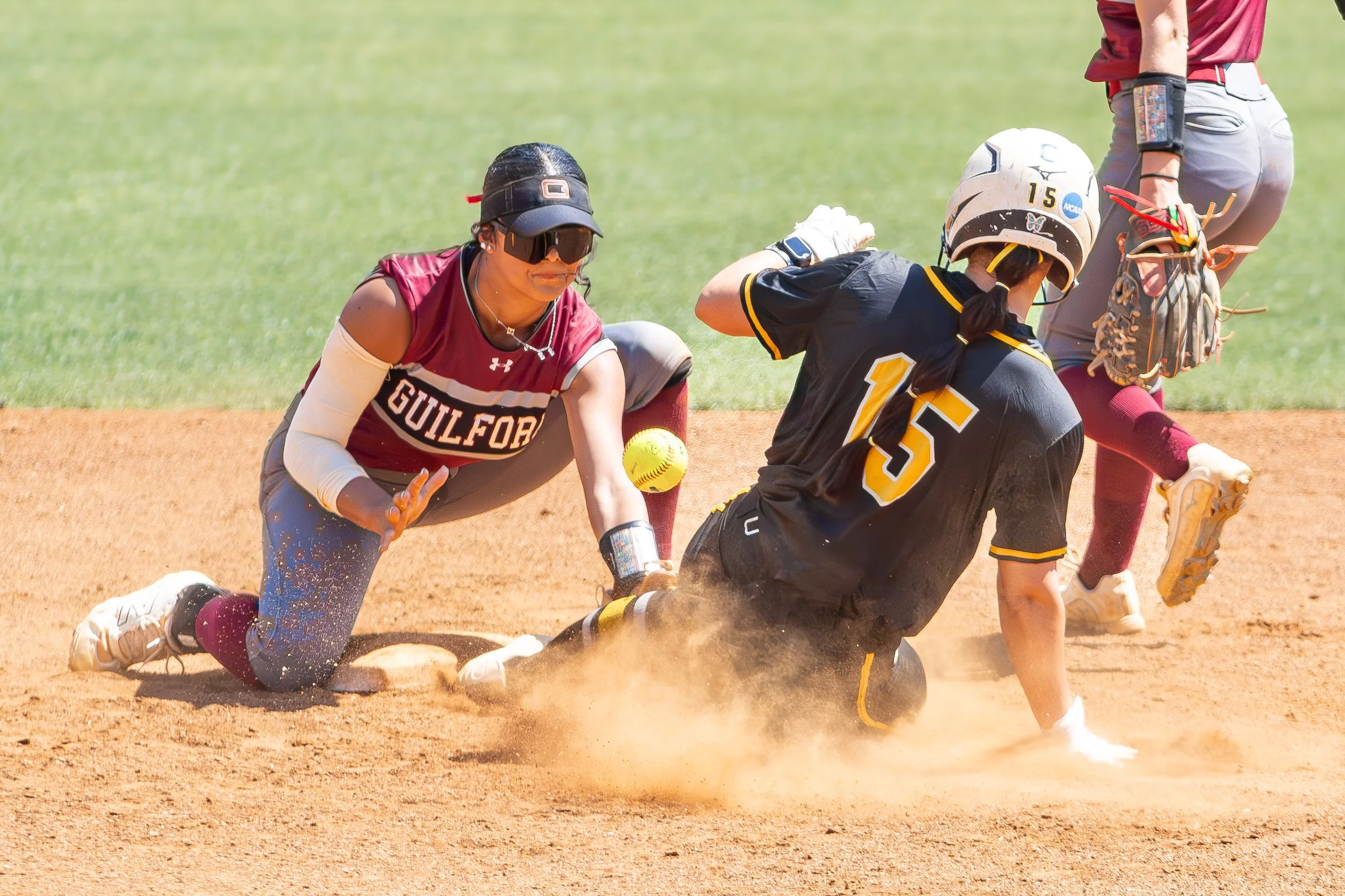 A female softball player from Guilford slides into second base as a player from the black team attempts to tag her out during a game.