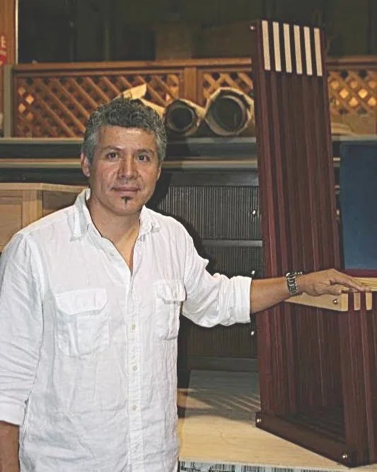 Gaspar Téllez junto a una pieza de mobiliario de diseño durante su trayectoria como maestro ebanista y artesano.
