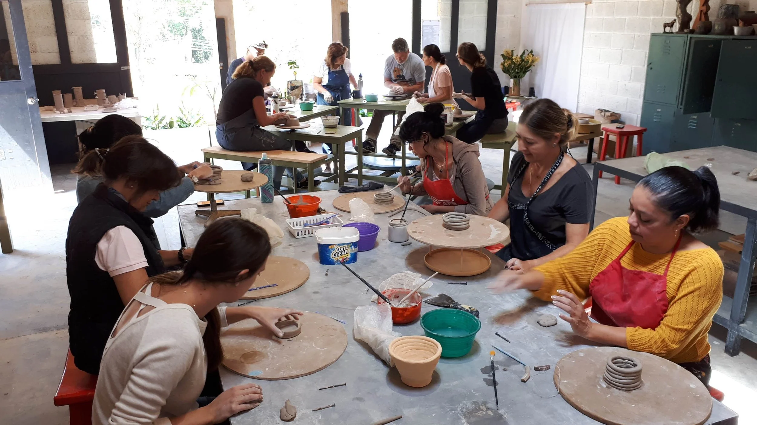 Alumnas trabajando con barro y técnicas de construcción manual en un taller de cerámica.